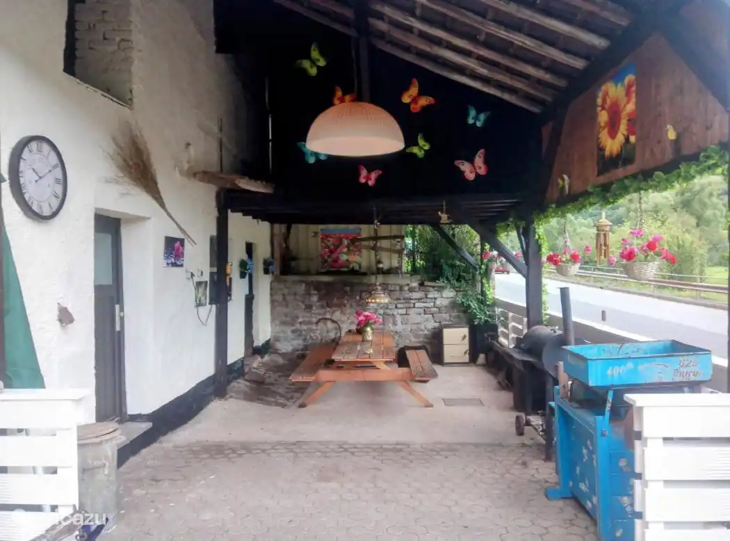 Bajo la terraza cubierta, hay un banco de picnic para 10 personas