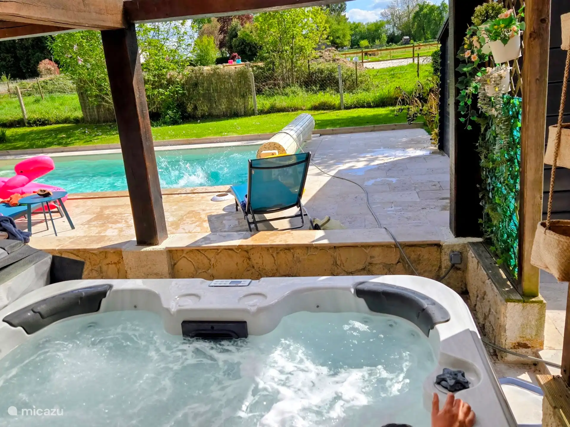 Blick auf das Becken und die Natur (manchmal Pferde) vom sprudelnden Spa aus 