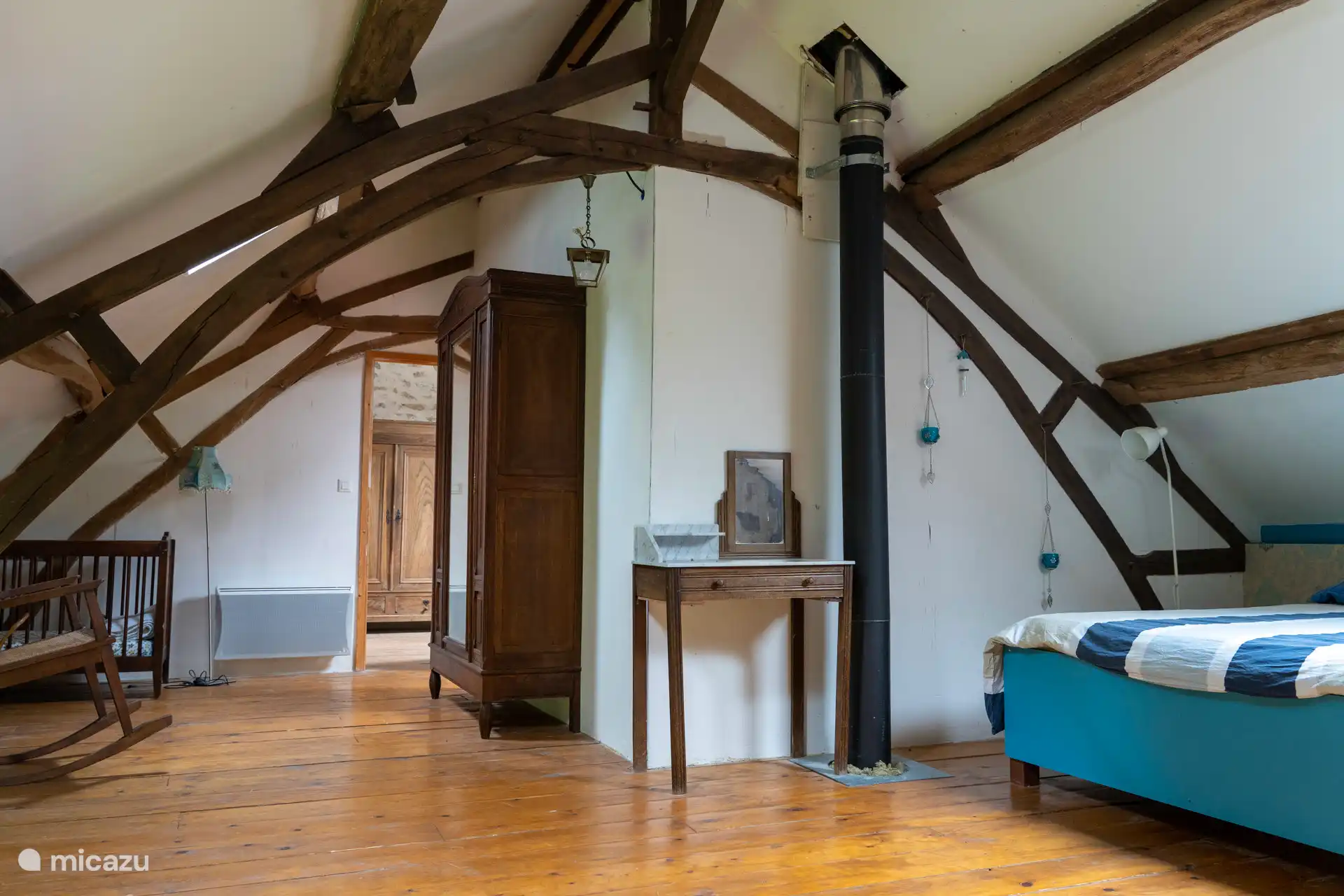 Slaapkamer 2. Door deze ruimte kom je bij slaapkamer 3 en 4. Er staat ook een babyledikantje. 