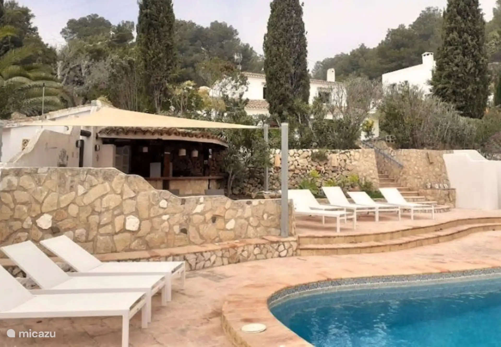 La piscina está rodeada de tumbonas.