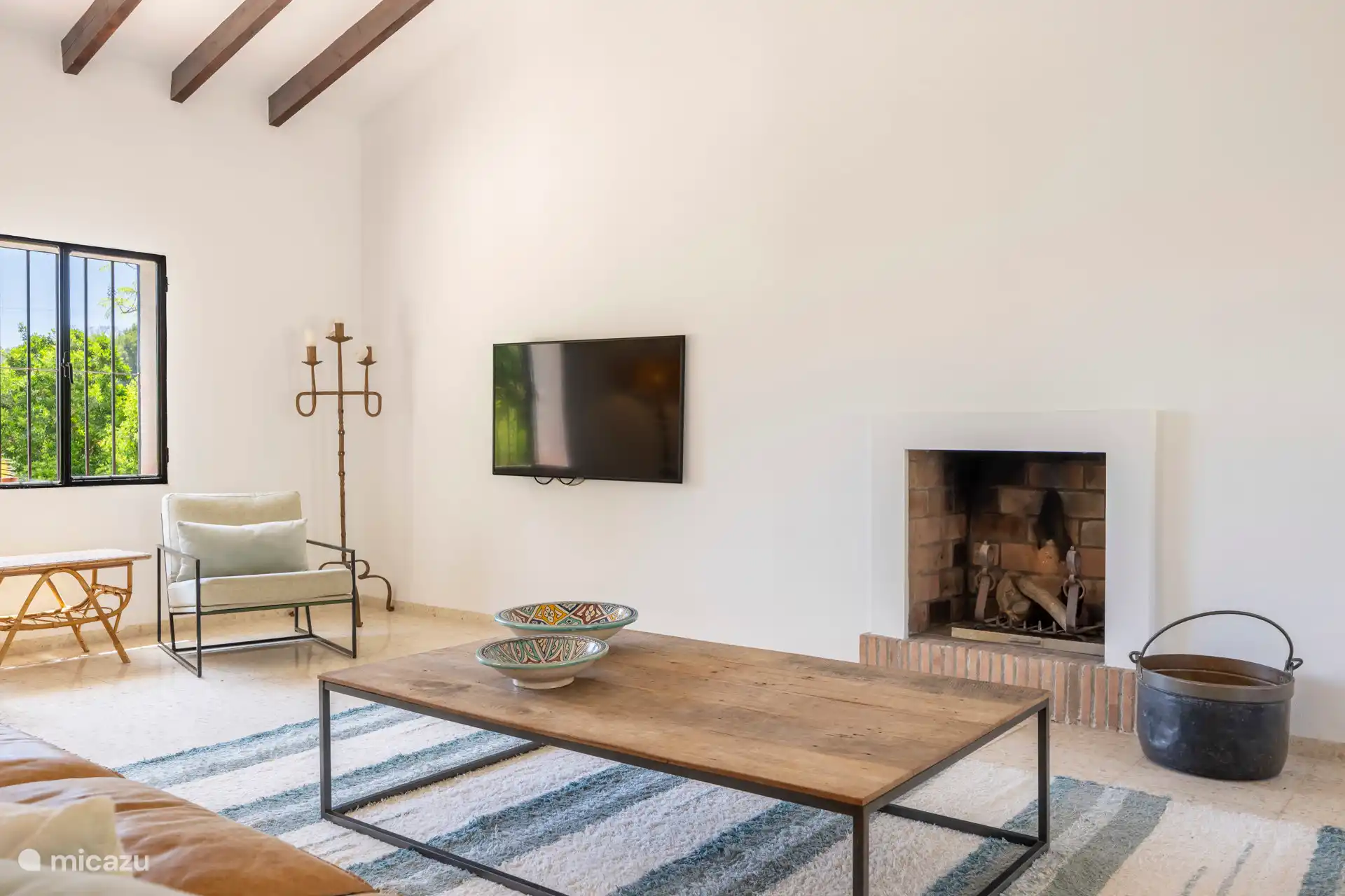 Das gemütliche Wohnzimmer mit gemütlicher Sitzecke, Fernseher und Kamin.