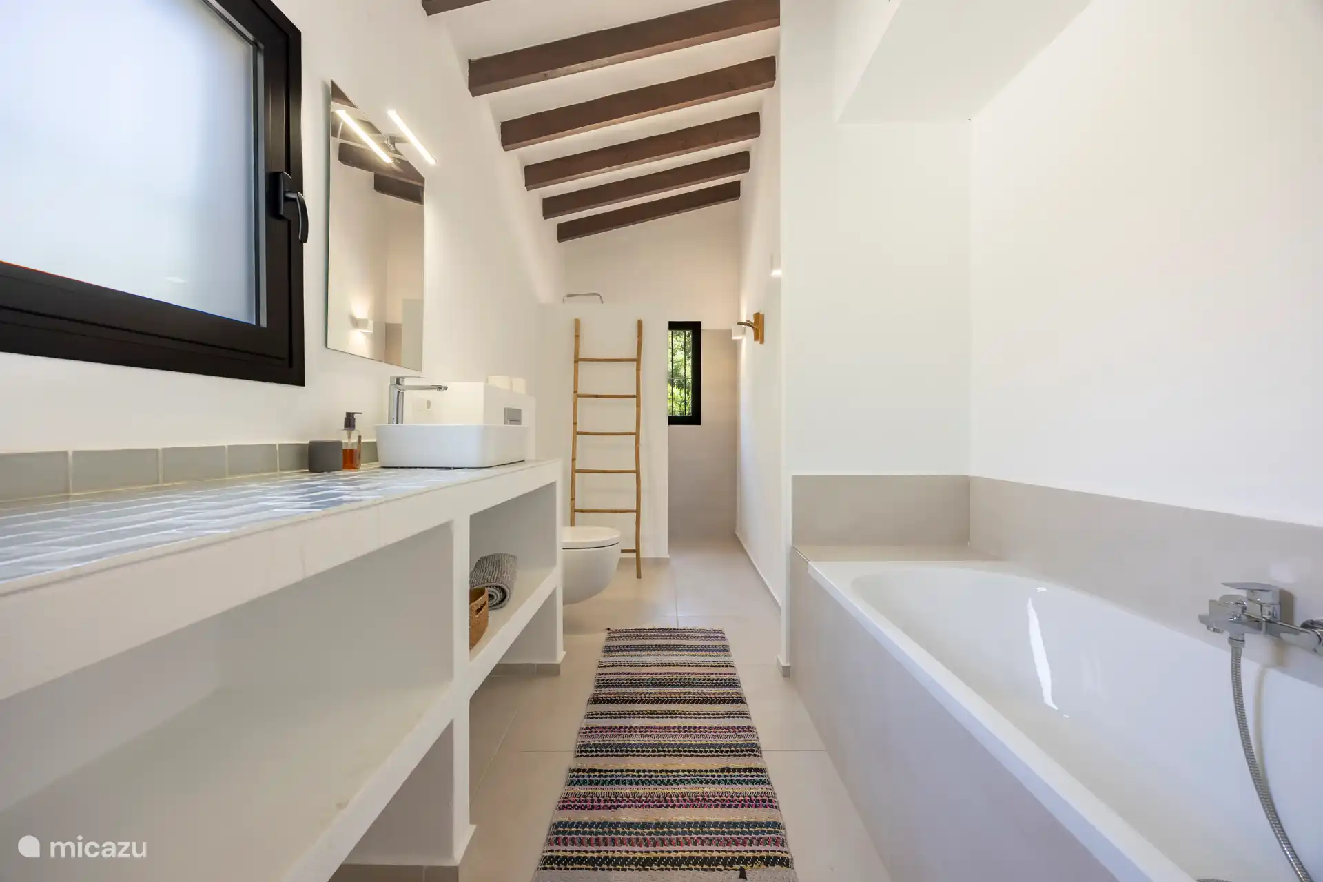 Badezimmer mit Badewanne, begehbarer Dusche, Waschbecken und Toilette.