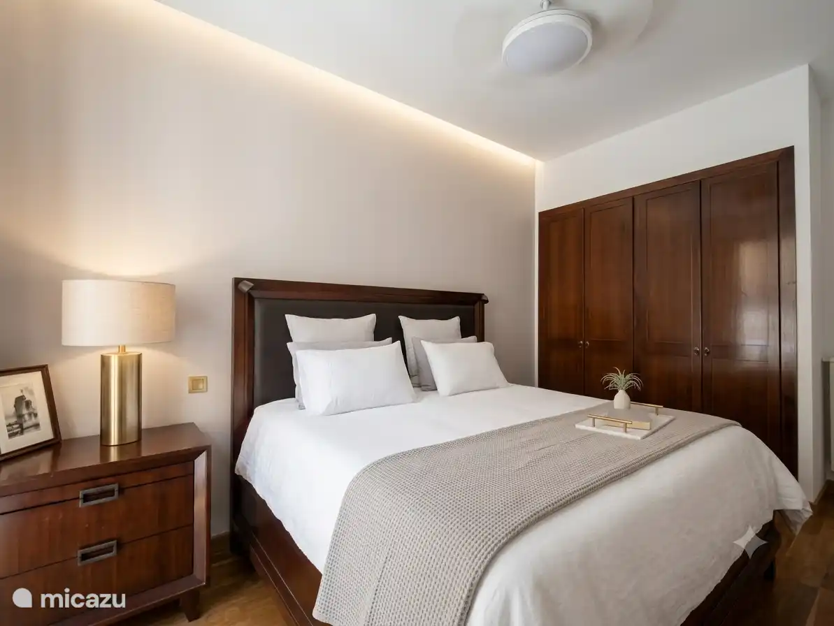 Ruime slaapkamer met een kingsize bed van 2 bij 2 meter.