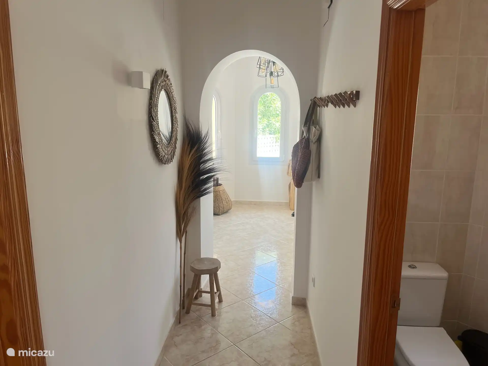 Le couloir vers la porte d’entrée et aussi la porte arrière de l’autre côté. Toilettes spacieuses à droite.