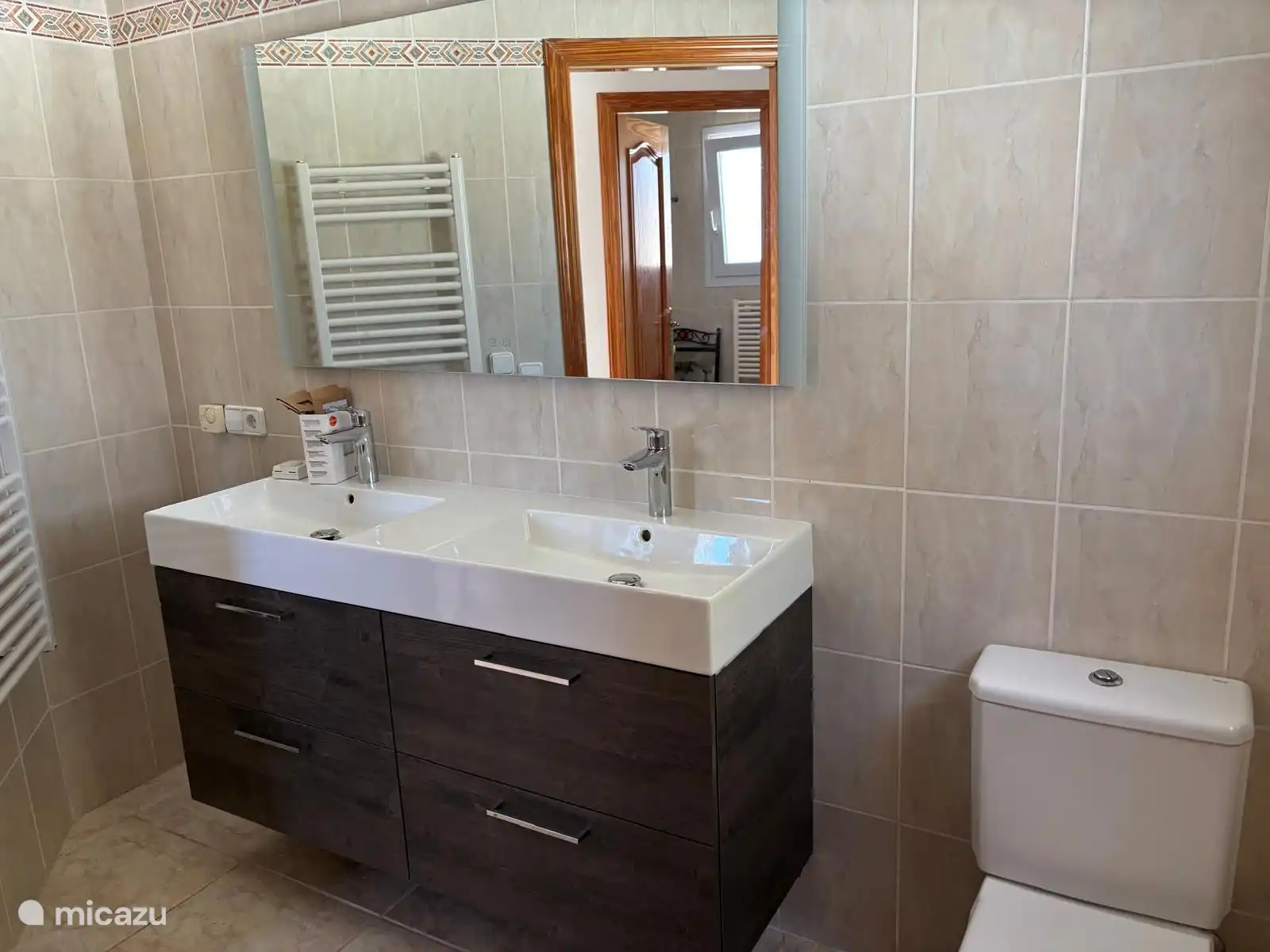 Salle de bain avec douche renouvelée, meubles de salle de bain et toilettes renouvelés.