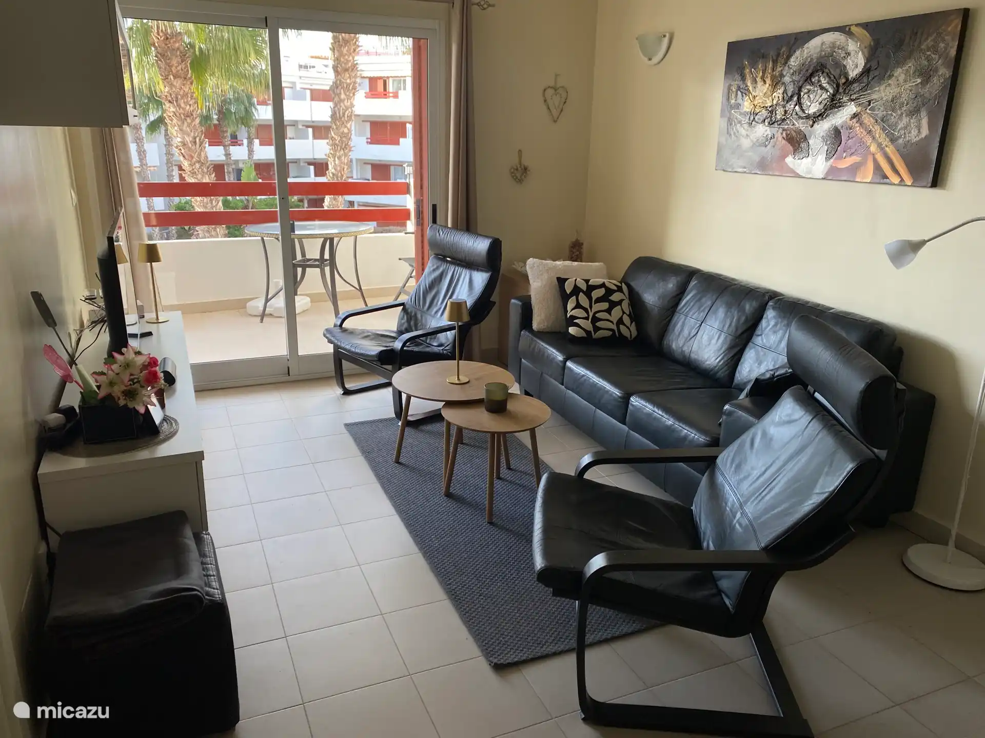 Salón con zona de estar con dos sillones de lujo y un sofá de cuero para 3 personas