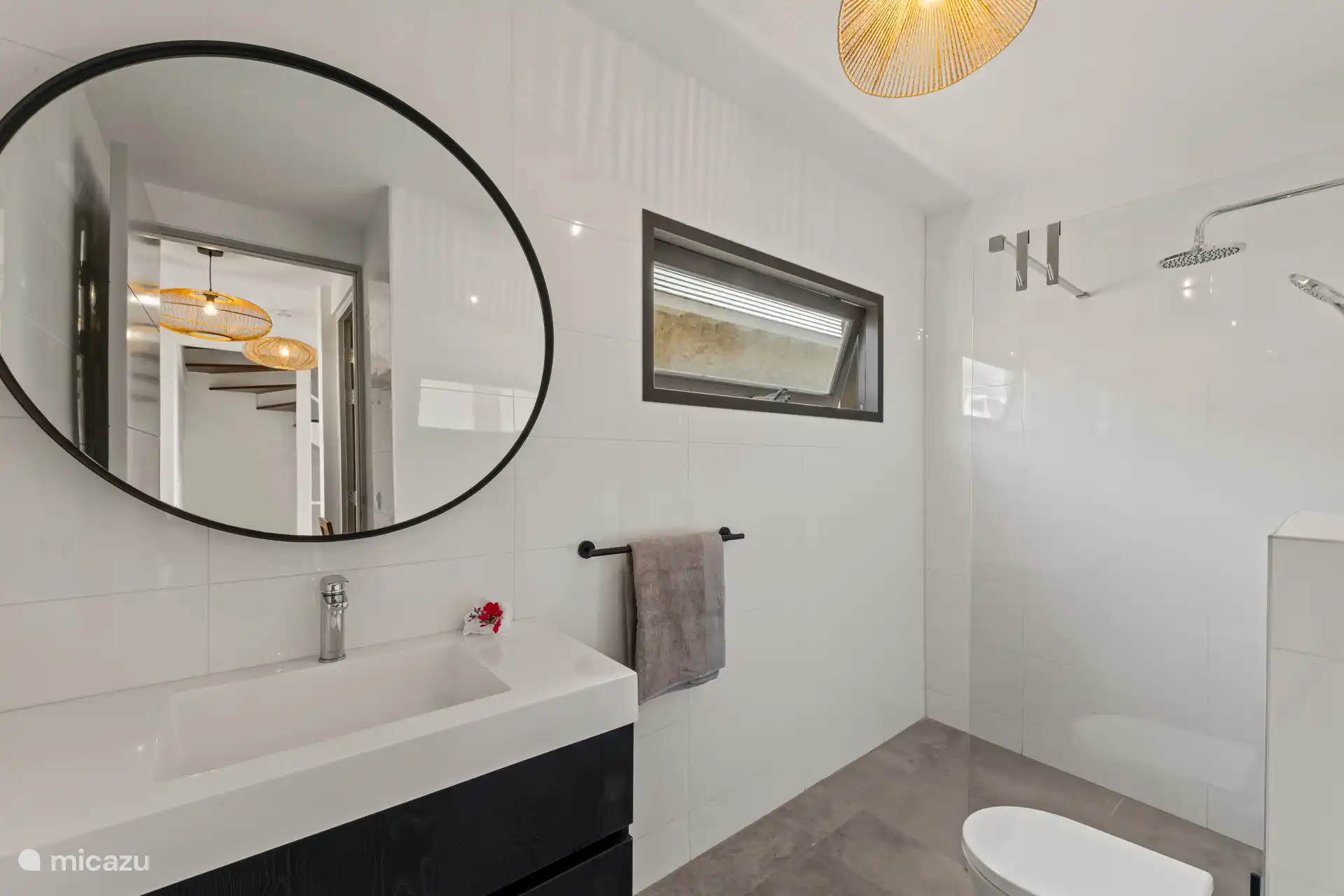 Schönes Badezimmer mit Regendusche, Toilette und großzügigem Waschbecken