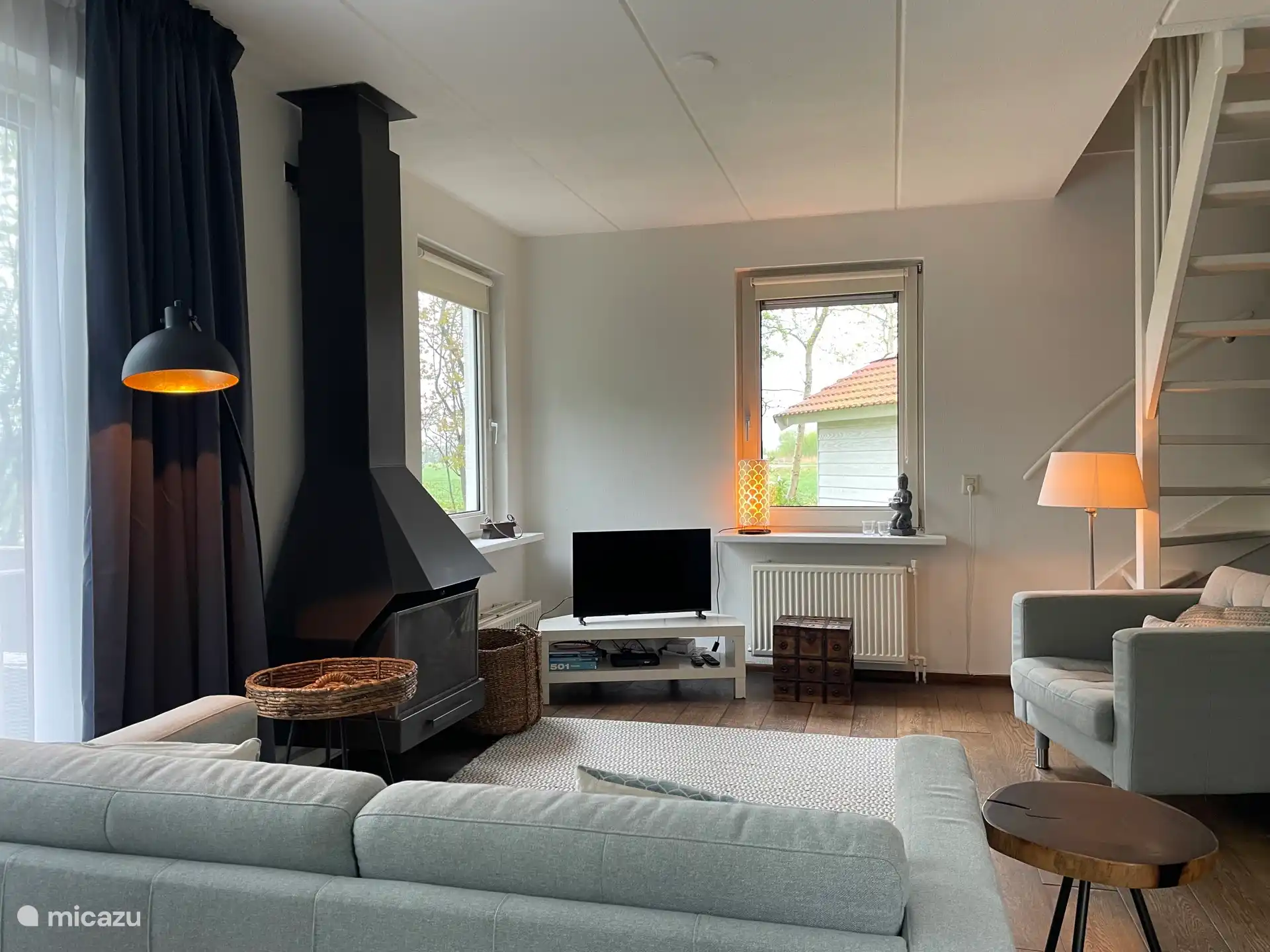 Salon spacieux avec cheminée et télévision. 