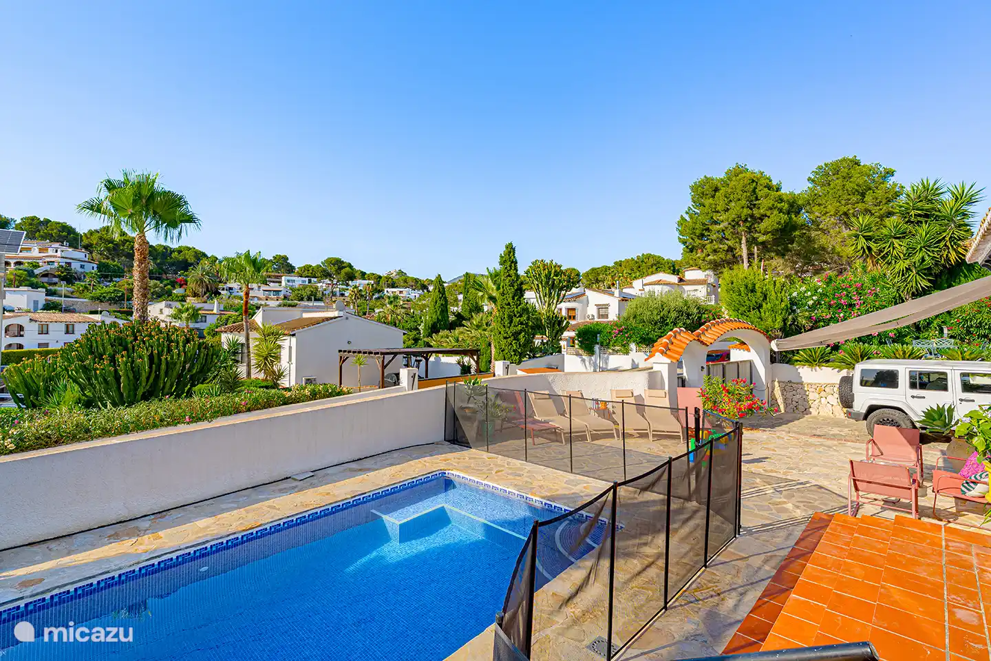 Überblick über die Poolterrasse mit Sicherheitszaun und den ruhigen, grünen Bereich von Pla del Mar. Ideal für Familien mit kleinen Kindern und alle, die Privatsphäre mögen.