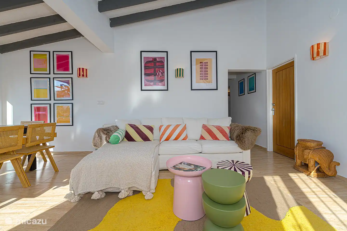 Helles und gemütliches Wohnzimmer mit bequemer Sitzecke, hohen Decken und Terrassentüren zur Terrasse und zum Pool.