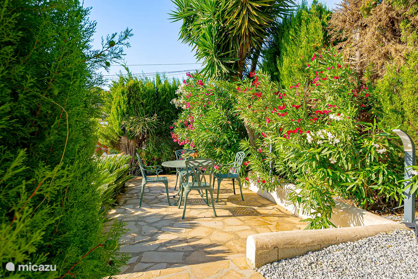 Versteckt zwischen dem Grün findest du einen zusätzlichen Sitzbereich im Garten. Ein wunderbar ruhiger Ort, um ein Buch zu lesen, eine Tasse Kaffee zu trinken oder der Sonne zu entkommen.
