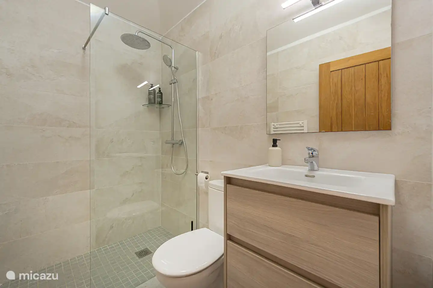 Das zweite Badezimmer ist modern eingerichtet und mit einer geräumigen begehbaren Dusche und Waschbecken ausgestattet. Ideal für Familien oder wenn Sie mit mehreren Personen in der Villa wohnen.