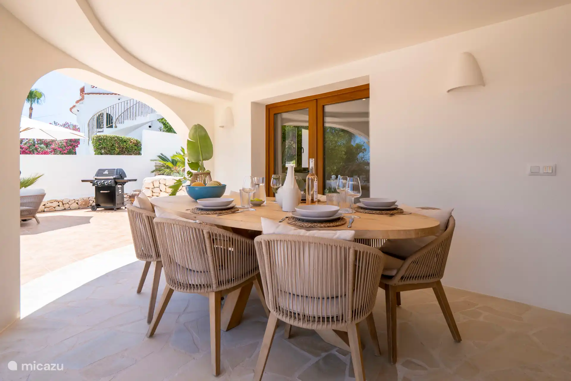 Überdachte Terrasse mit Esstisch und 6 Stühlen.