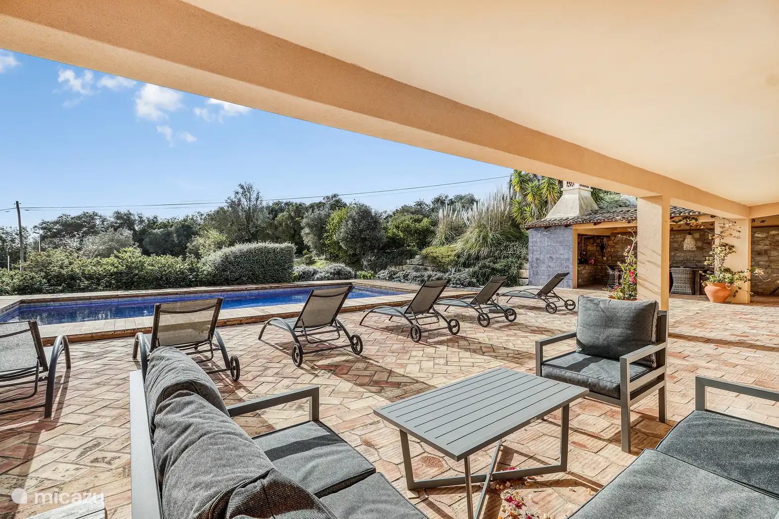 La piscina está en la parte trasera de la casa, en el lado sur. Aquí también hay una zona de asientos cubierta. 