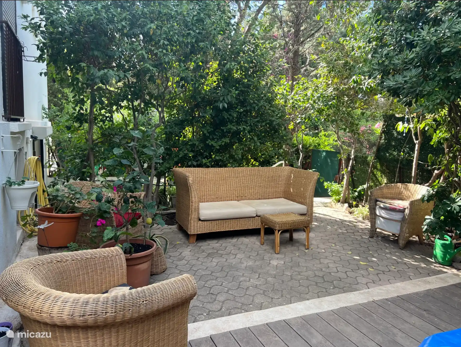 Zona tranquila del jardín con sofá y sillones