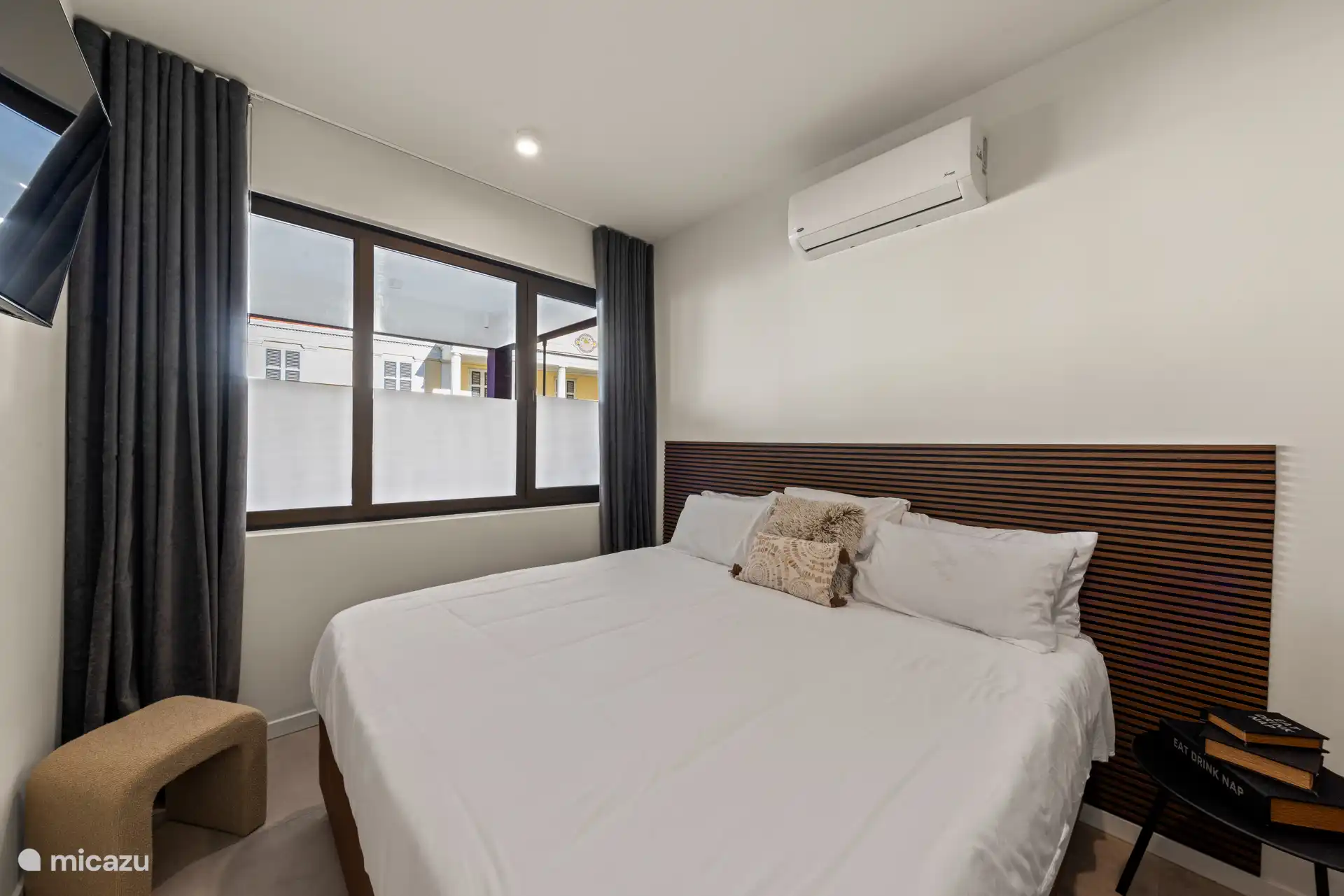 El dormitorio principal cuenta con una cómoda cama king size, aire acondicionado, un espacioso armario empotrado y su propia smart TV.