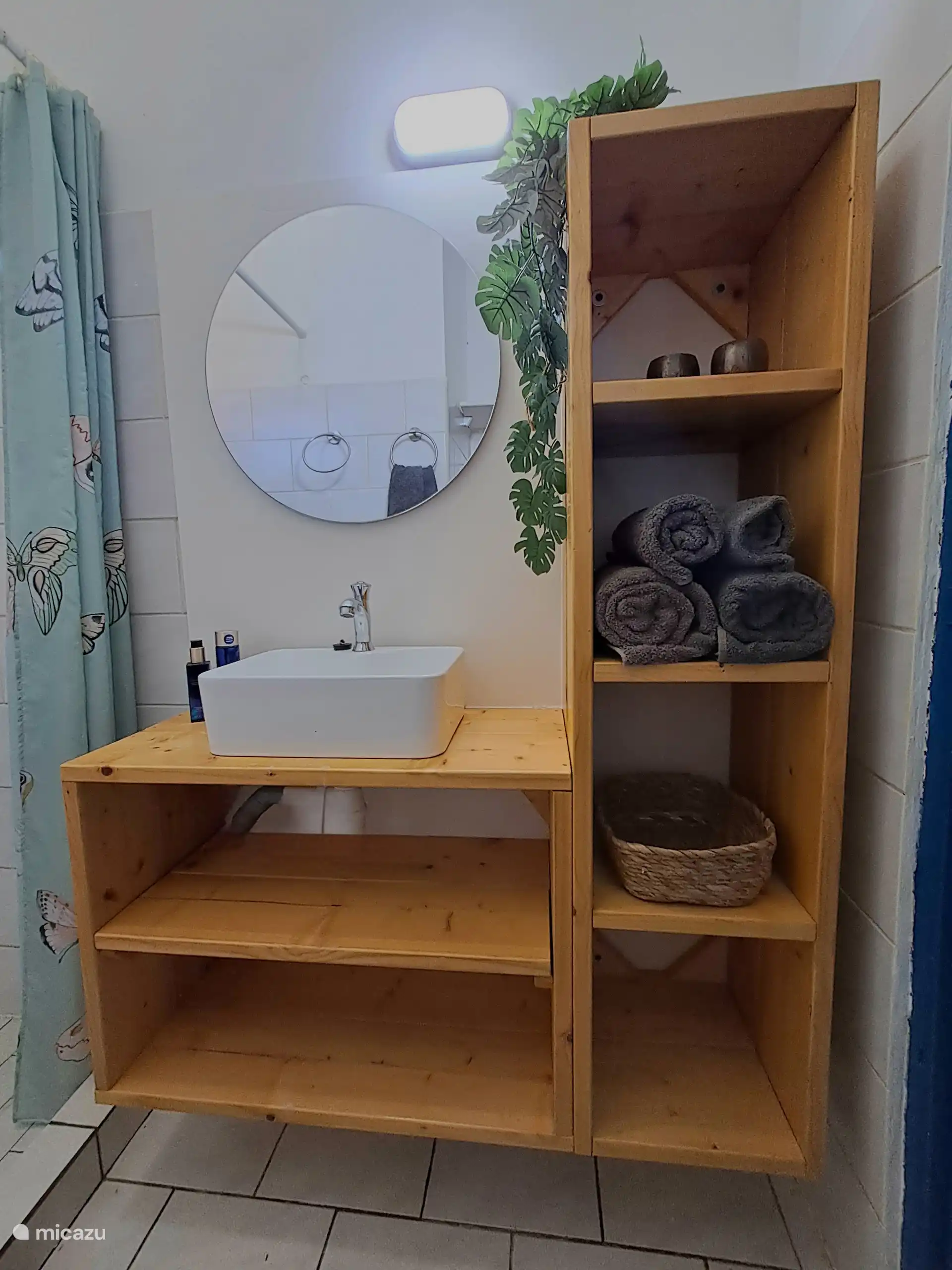 Primer plano del mobiliario del lavabo en el baño con cómodos compartimentos para guardar toallas.