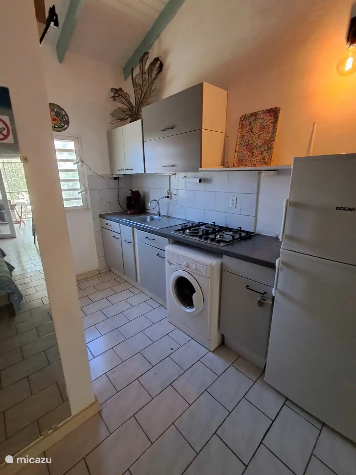Cocina totalmente equipada con cocina de gas, nevera y una lavadora práctica.