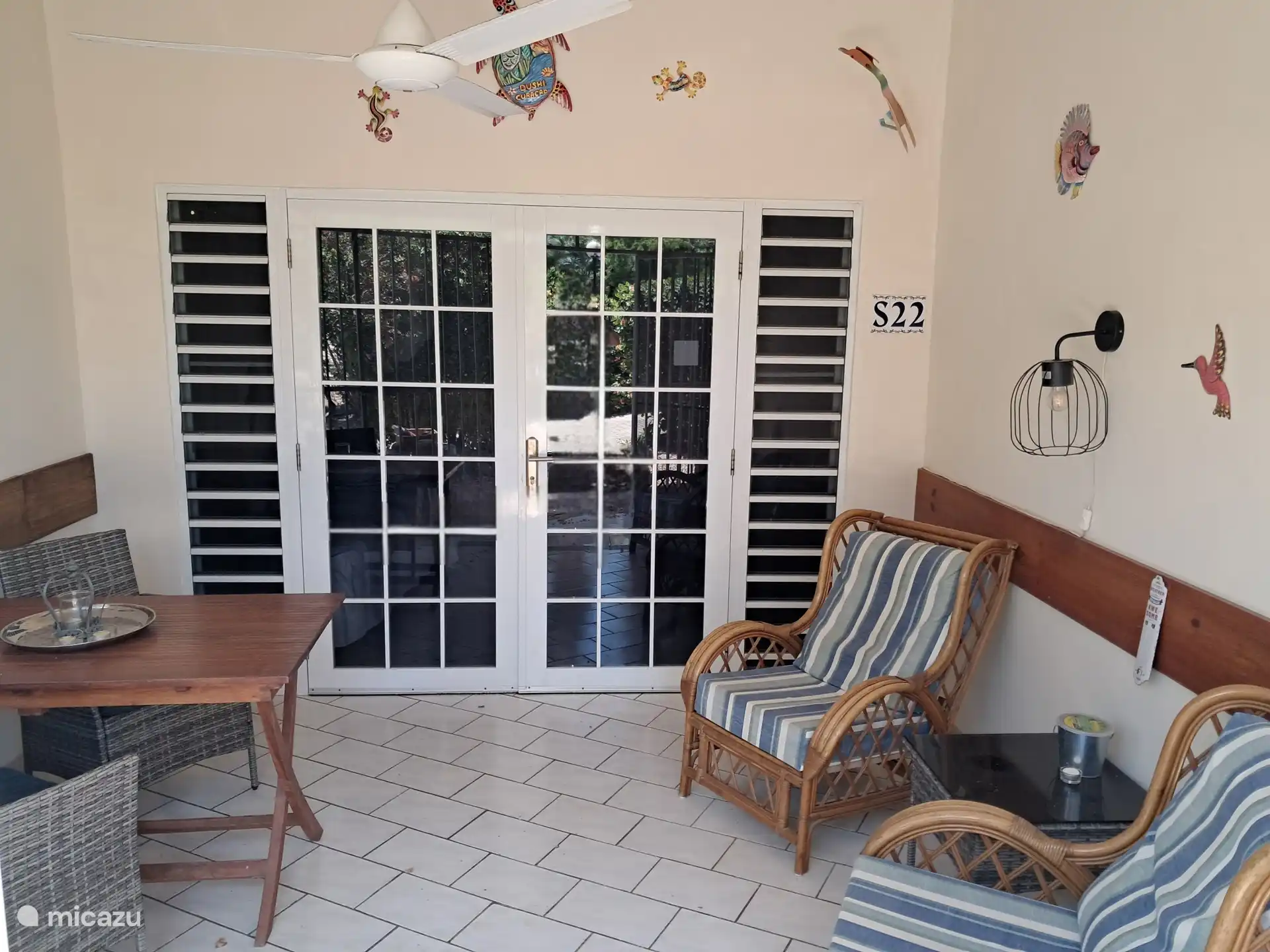 Acogedora terraza privada con sillones cómodos y puertas de patio hacia el estudio.