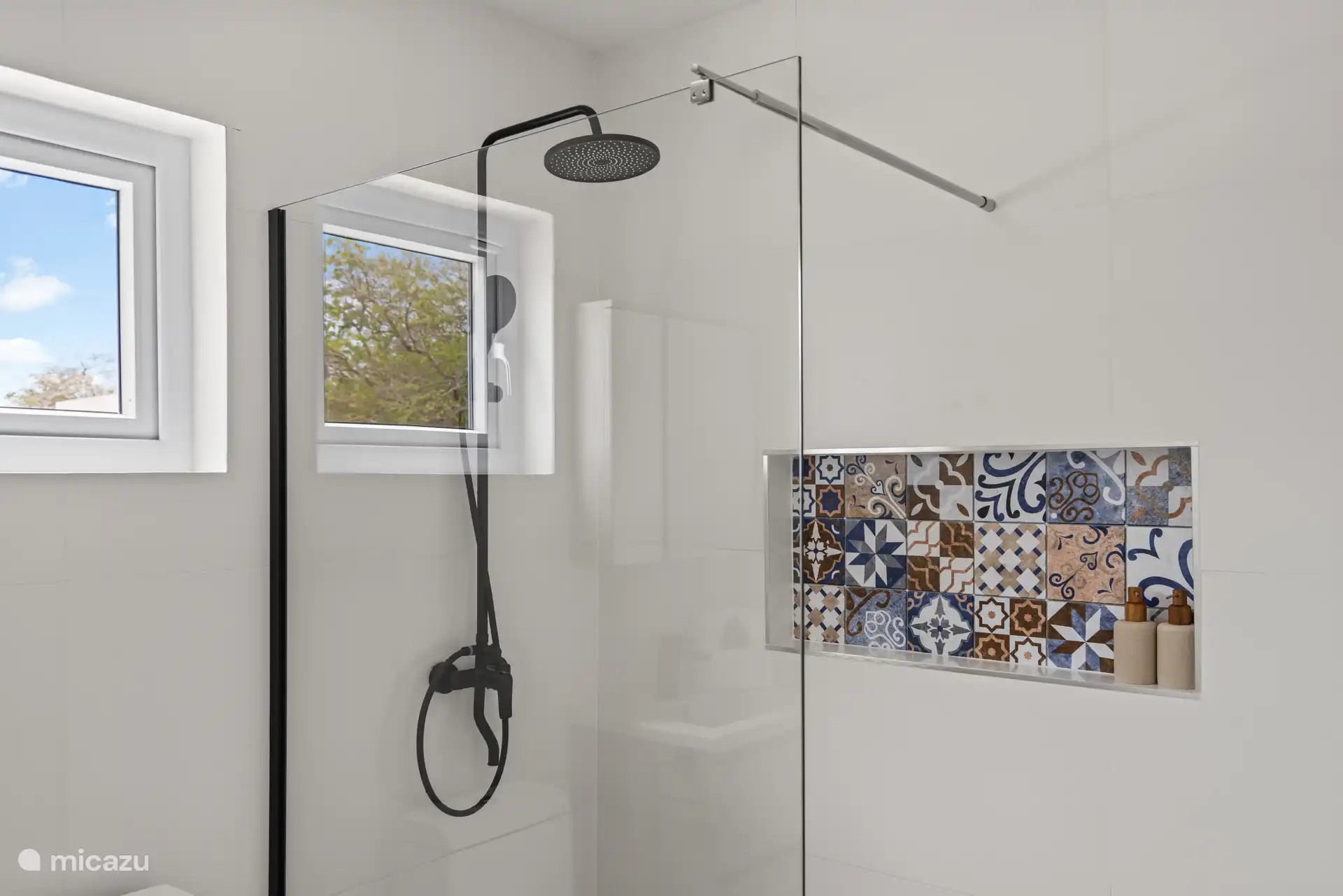 De moderne badkamer is voorzien van een ruime inloopdouche met regendouche en biedt alle comfort voor een ontspannen verblijf.