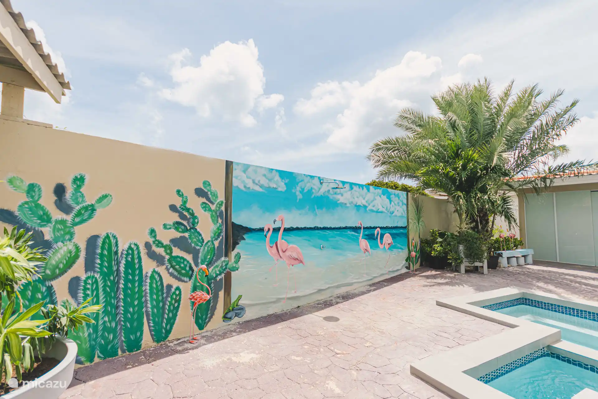 The apartment E has a shared balcony overlooking the pool with outdoor shower and the garden.
