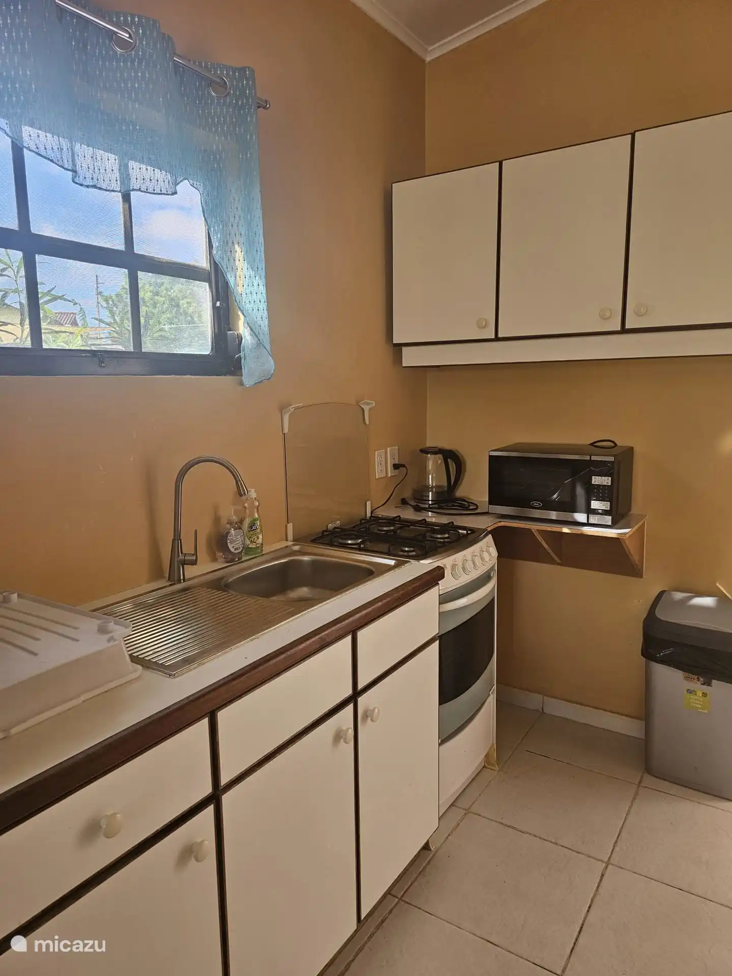 The kitchen is equipped with a 4 burner stove and refrigerator and various kitchen appliances, complete for riding and consuming a meal 