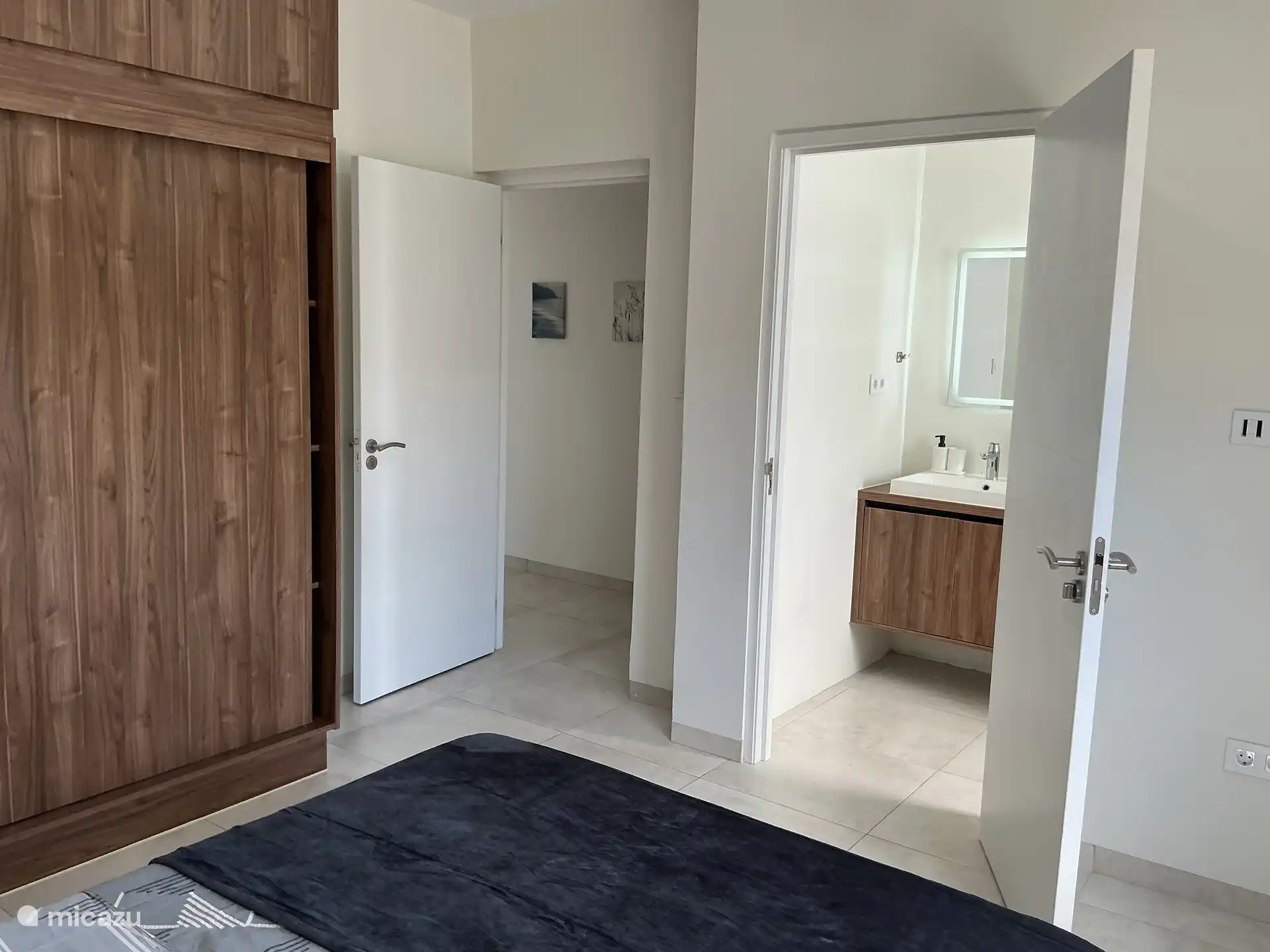 Slaapkamer 2: deur naar gang (links), ingang naar badkamer 2 (rechts)