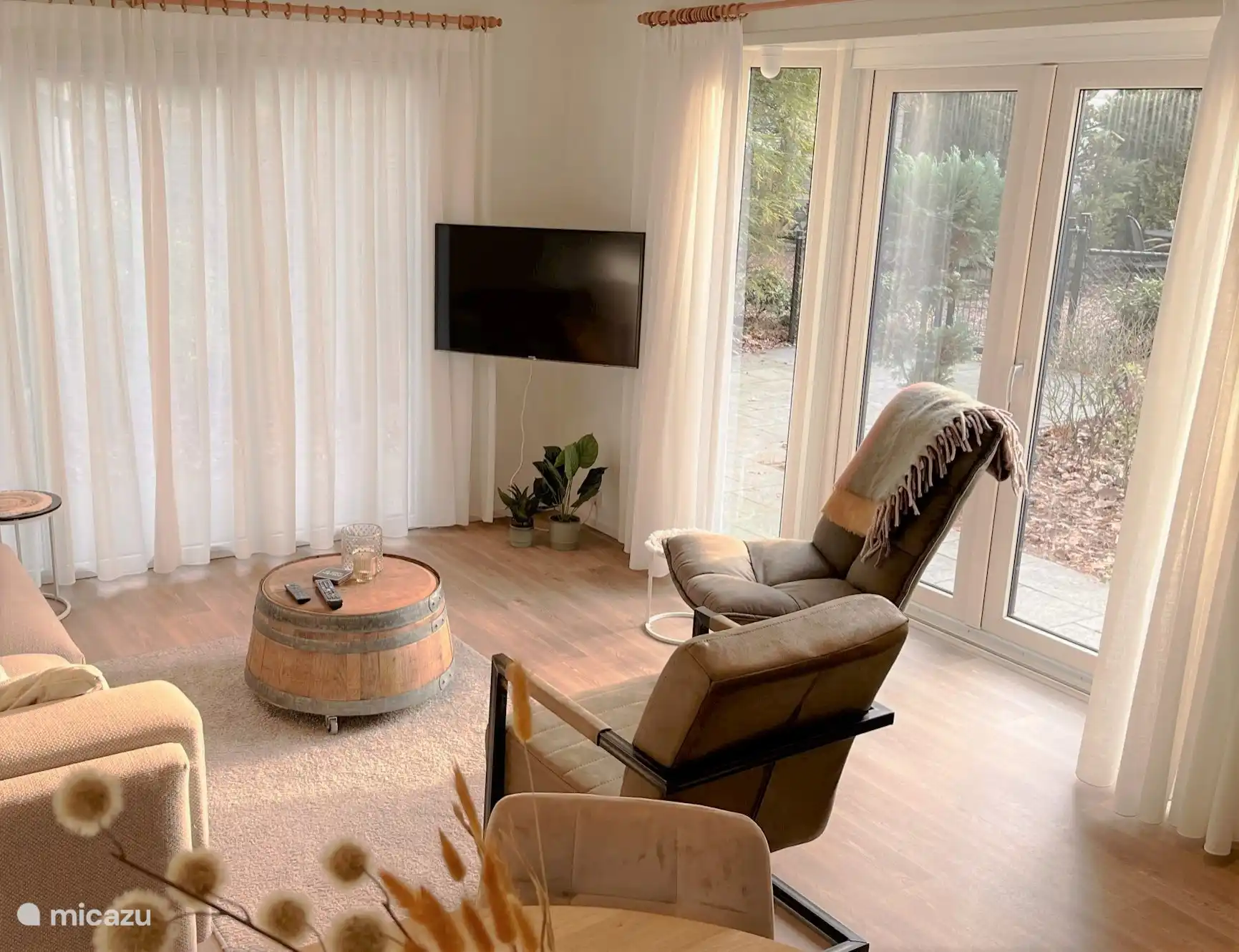 Ruime woonkamer met grote smart tv.