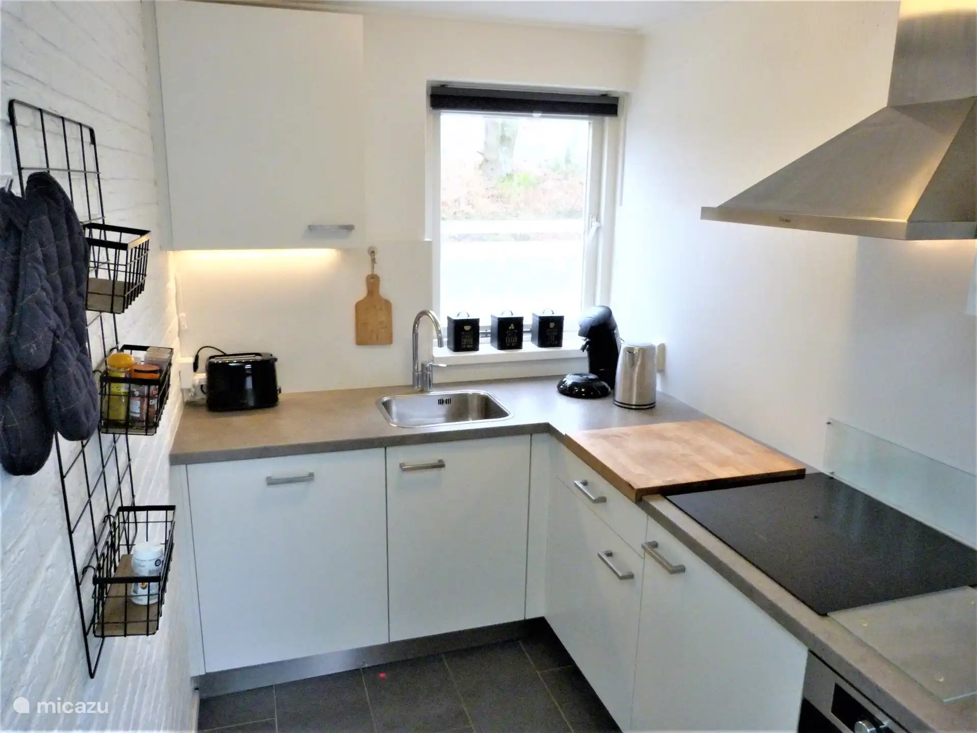 Küche mit Geschirrspüler, Kombimikrowelle, Dunstabzugshaube, Induktionsherd.
Großer Kühlschrank mit separatem Gefrierschrank.