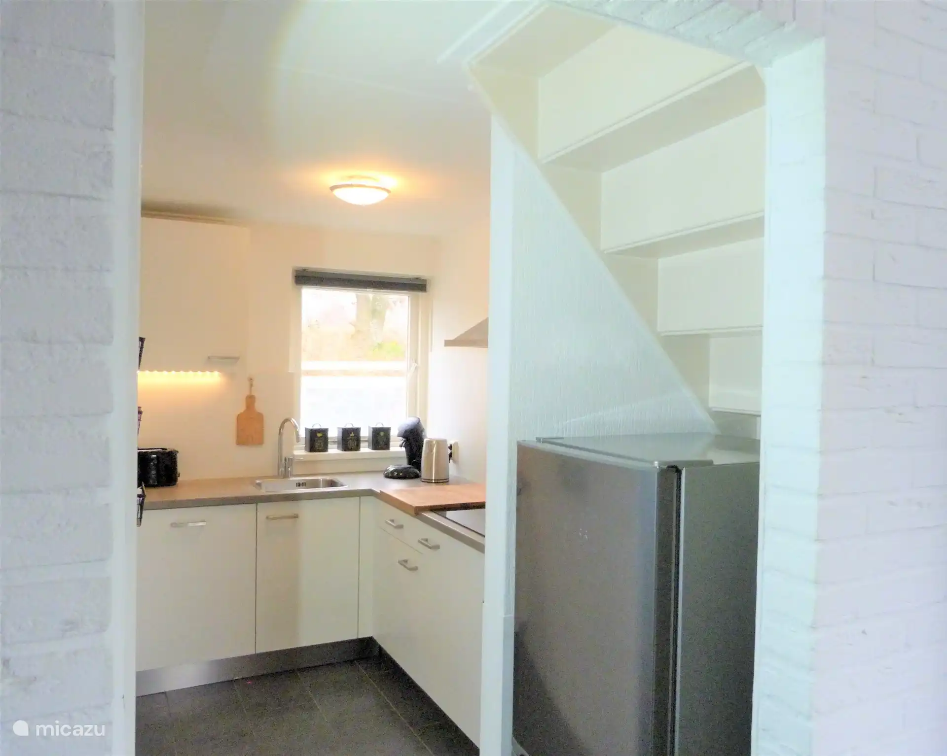 Die Küche mit dem großen Kühlschrank und separatem Gefrierfach unter der Treppe rechts.