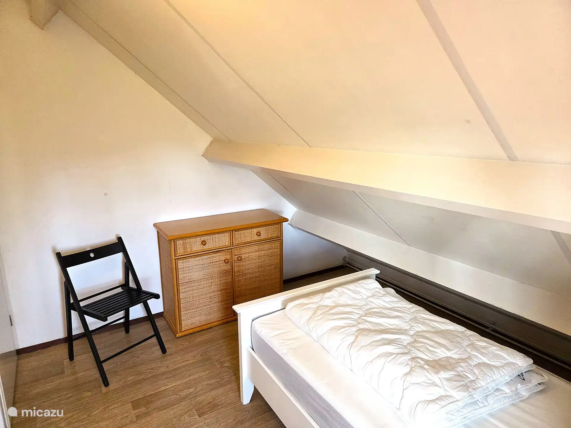 3. Schlafzimmer mit Einzelbett, Kleiderschrank und Stuhl.
Ganz links die Tür zum Podest.
