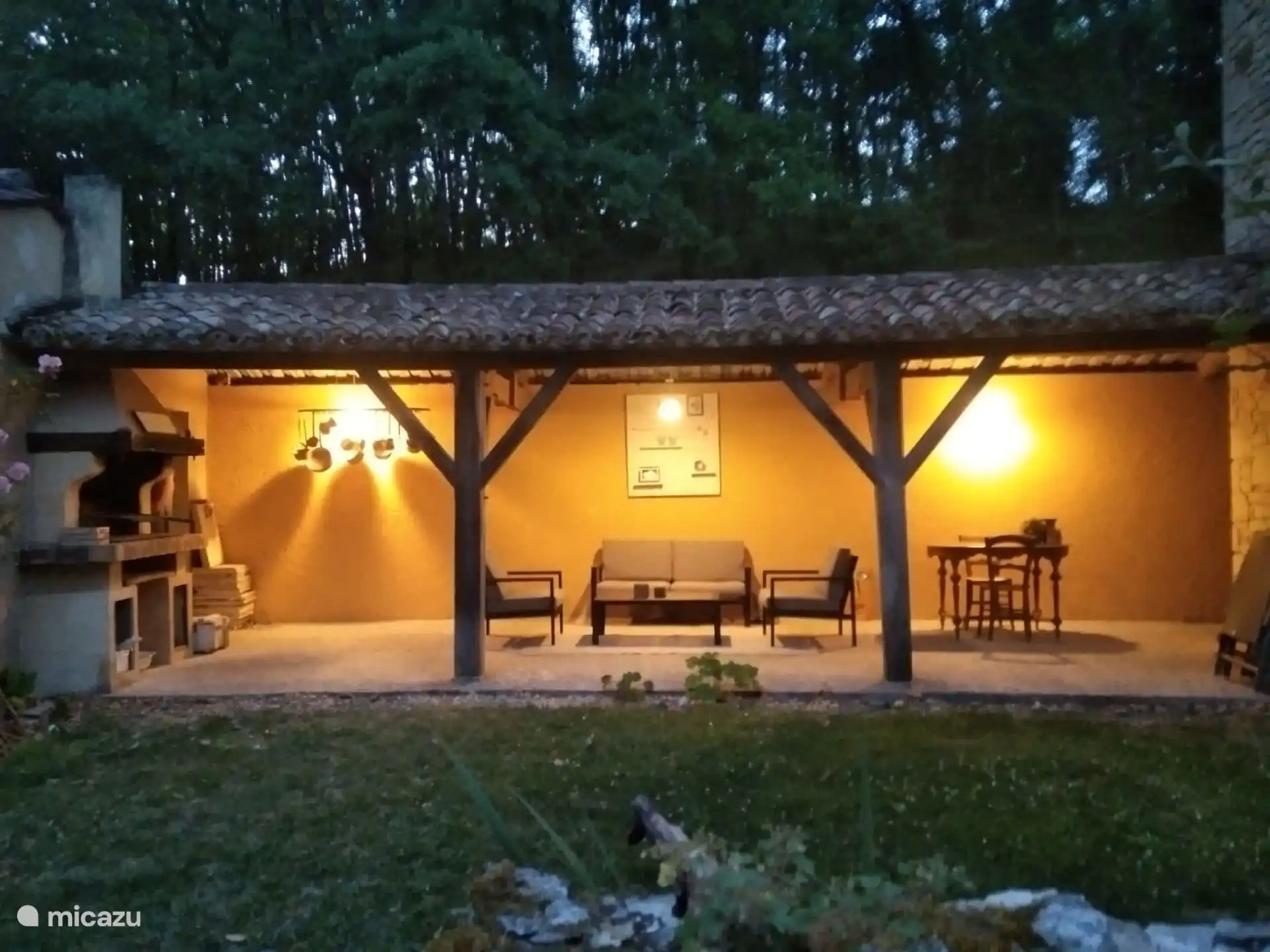 Auvent ombragé avec salon et table à manger avec chaises et jardin