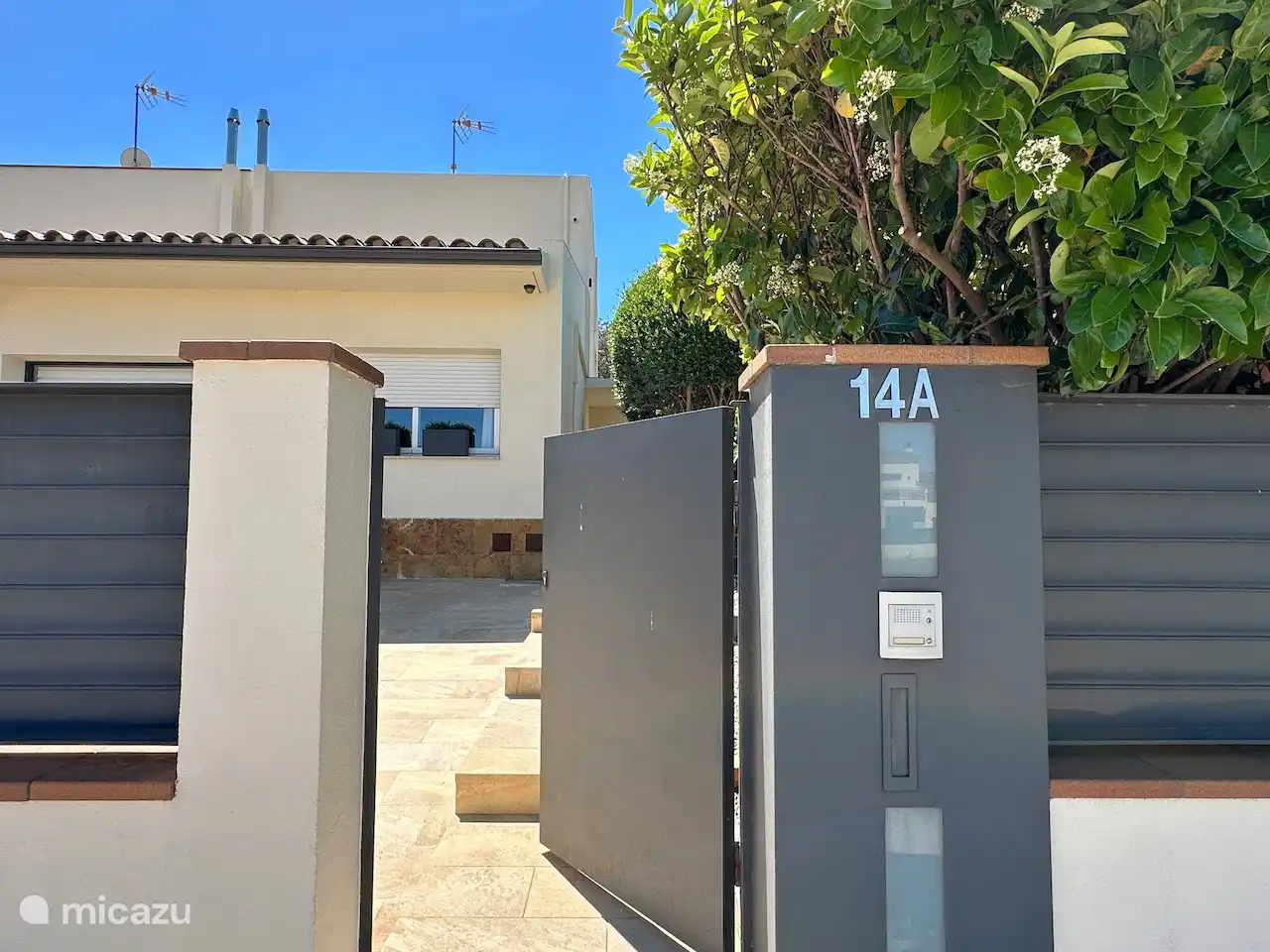 Devant l’entrée, à l’entrée.
