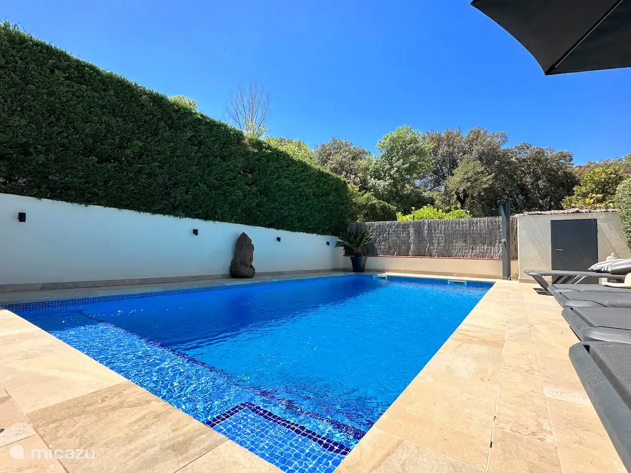 La piscine dispose d’un beau canapé et d’un large escalier intégré où l’on peut se détendre au soleil.
