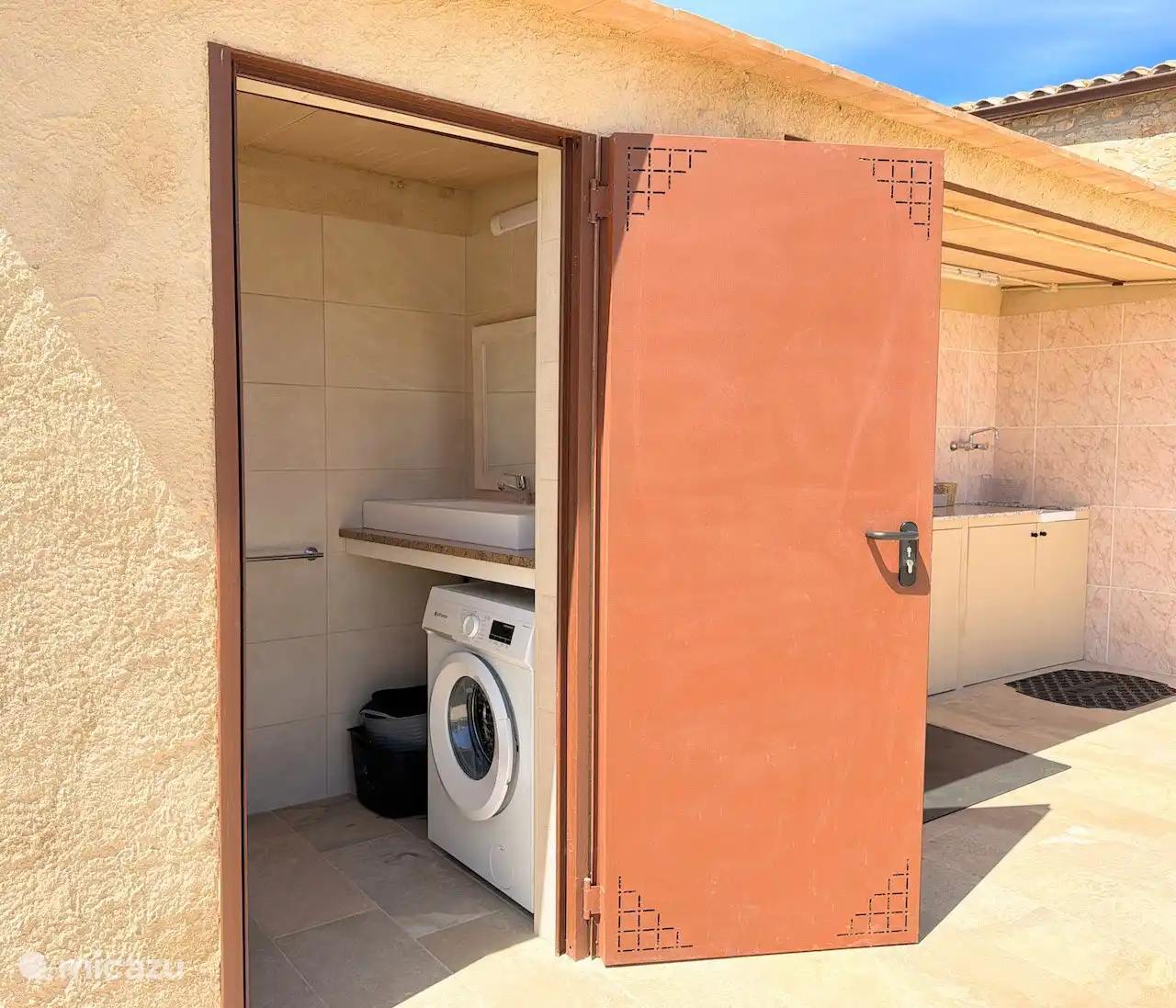 Separate room outside with washing machine and toilet, very practical.