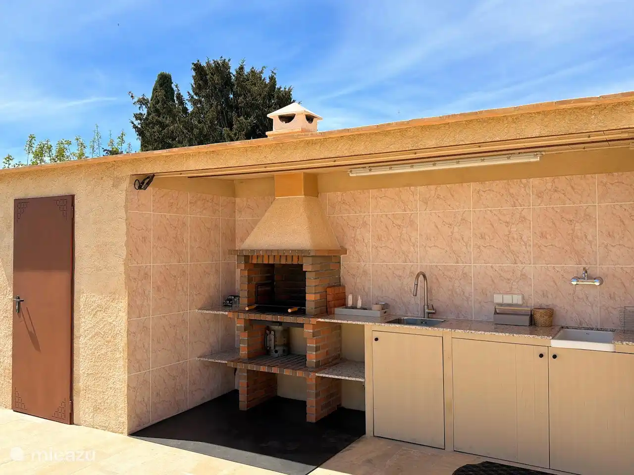 Covered outdoor kitchen with sink and barbecue. Ideal! There is also an extra sink to wash your swimwear.