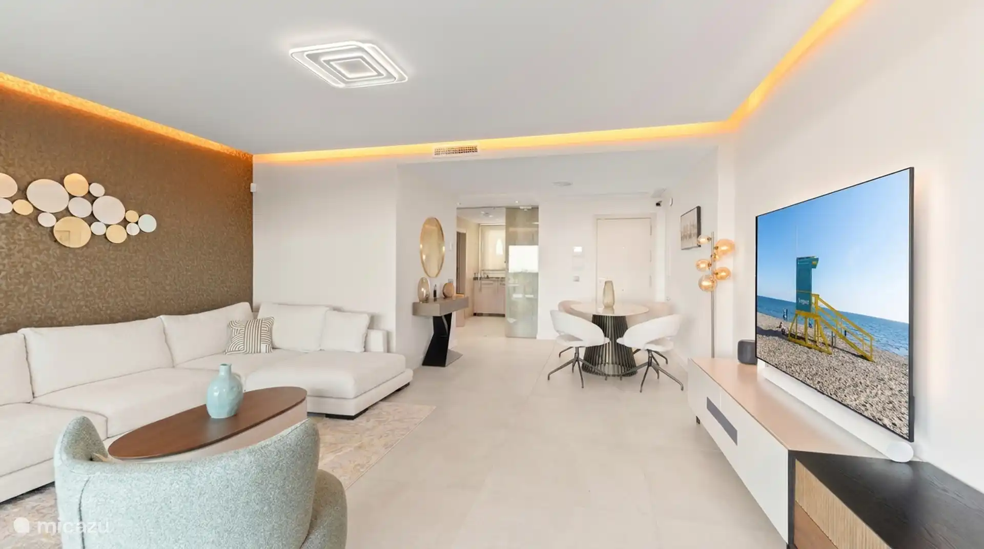 Sitting area with large television and open connection to the dining area