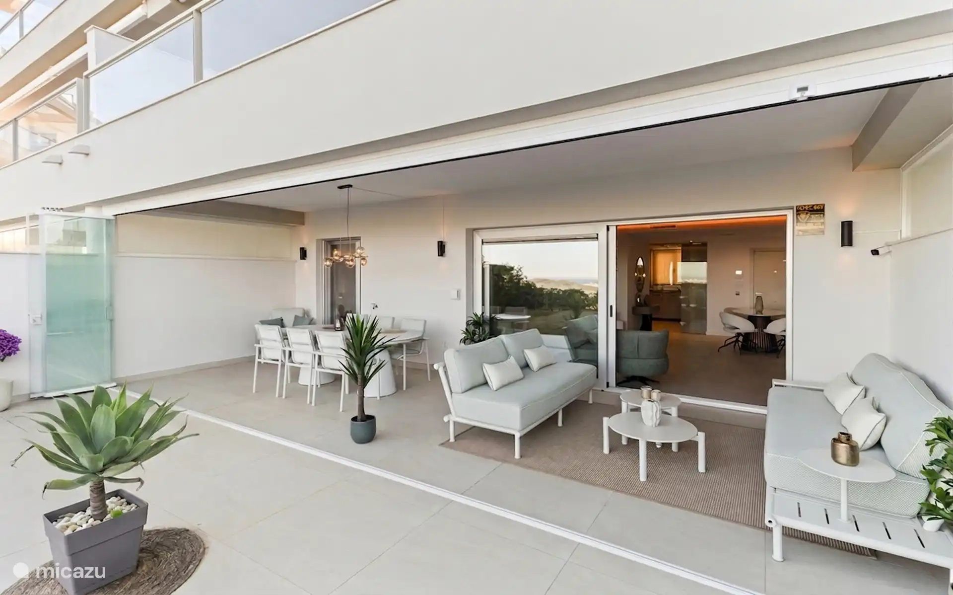 Covered terrace with dining table and lounge sofa