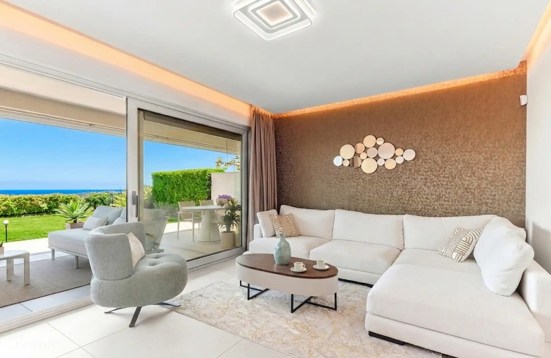 Living room with lounge sofa, terrace and sea view