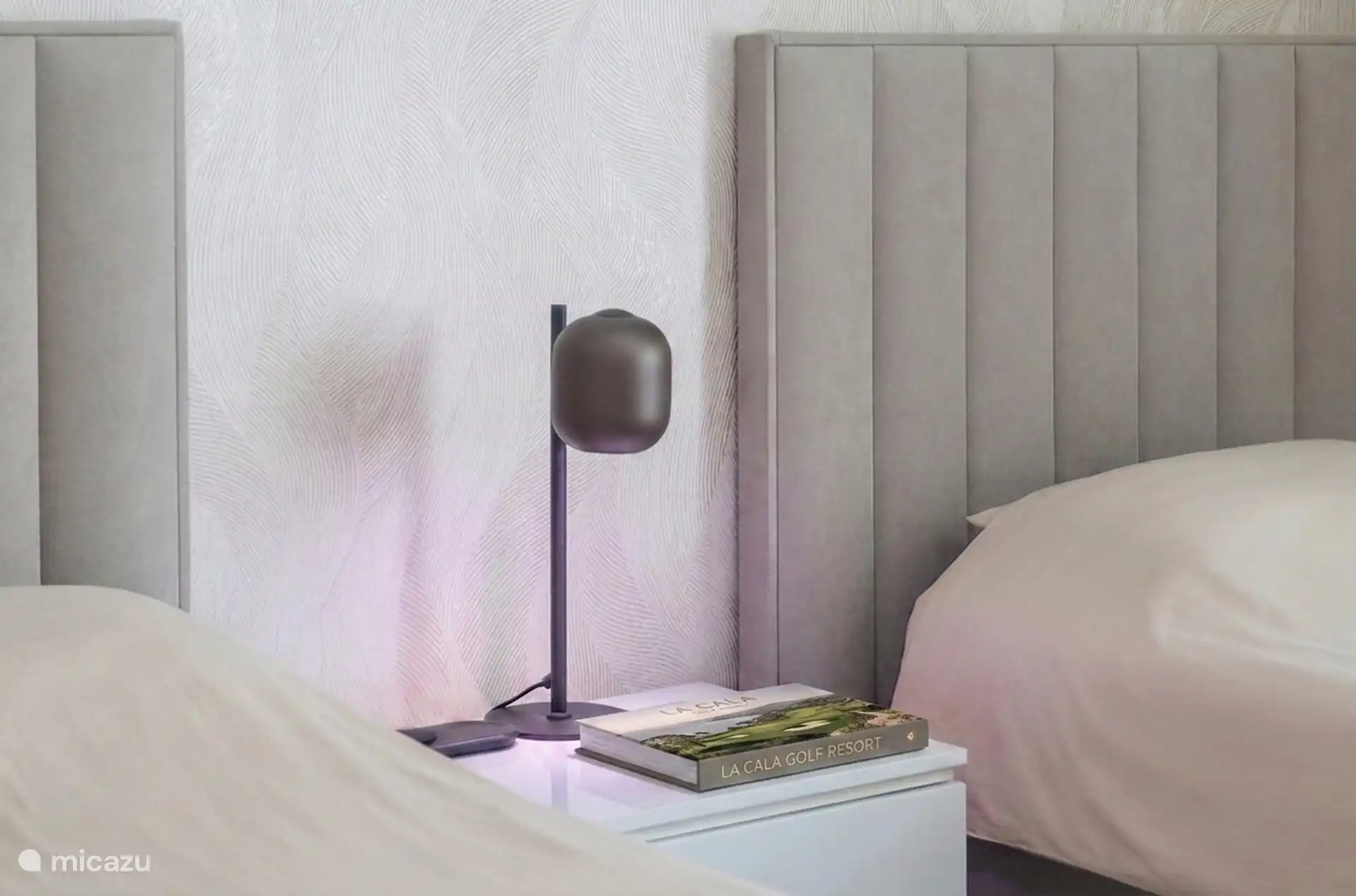 Bedroom detail with soft lighting and upholstered wall