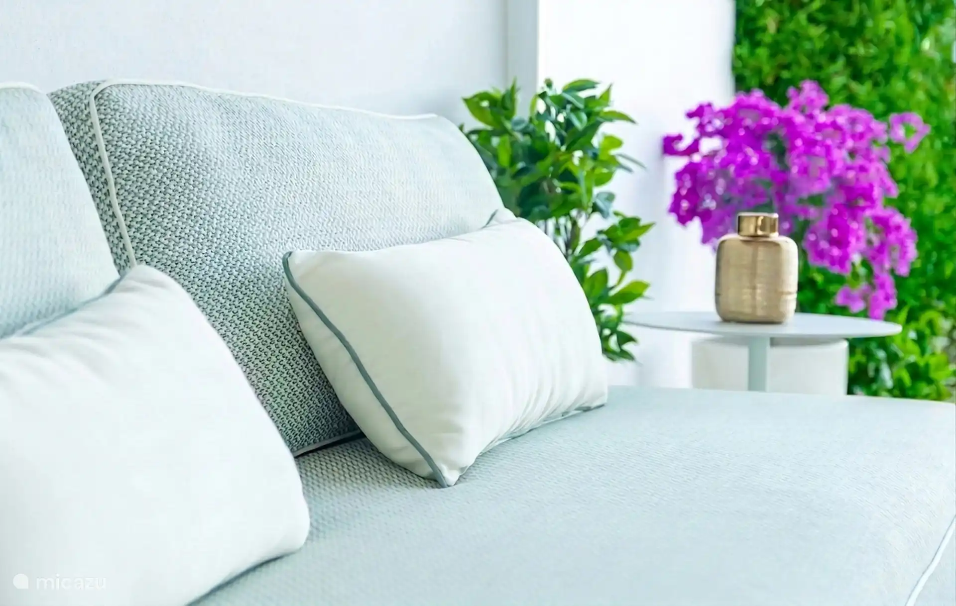 Lounge cushions on the terrace with blooming bougainvillea