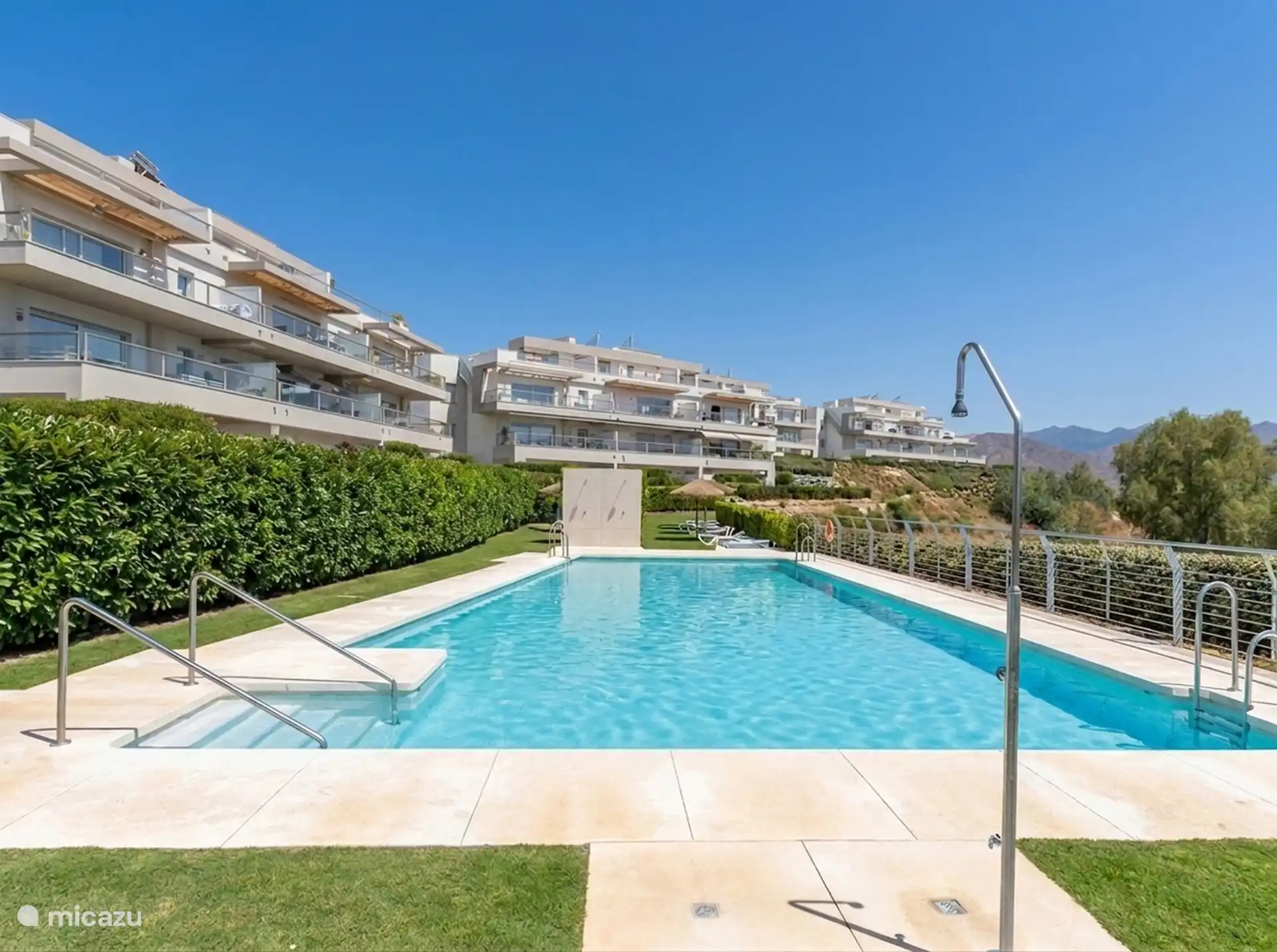Swimming pool with sunbeds between the resort's buildings