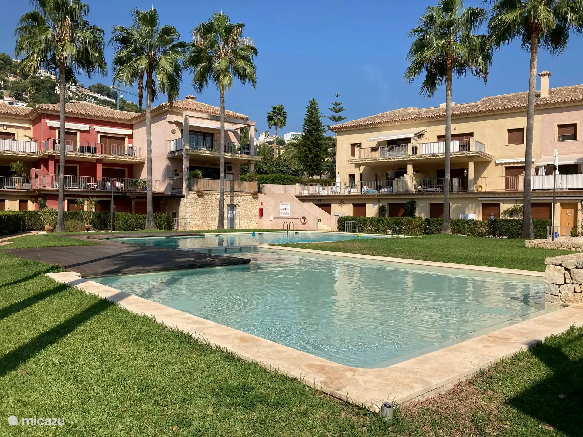 Buiten zwembad. Het rode bovenste appartement is ons appartement met terras op zuidzijde