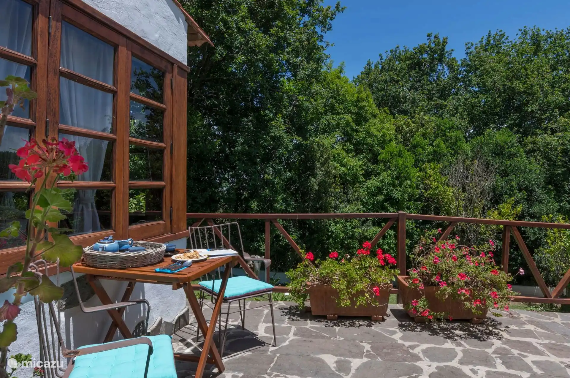 Terras met tafel en stoelen en uitzicht op de tuin