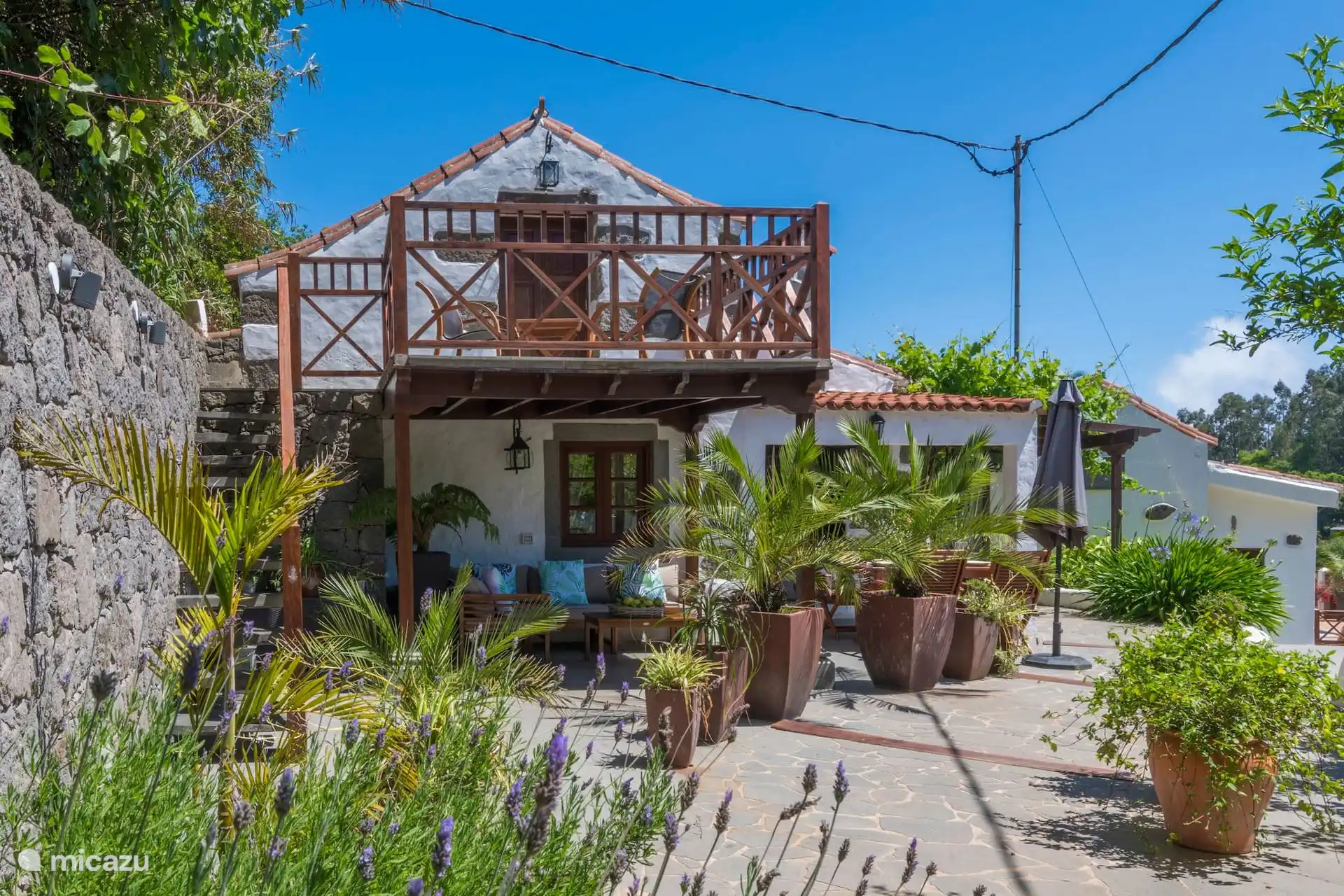 Gevel van het huisje met houten terras en balkon
