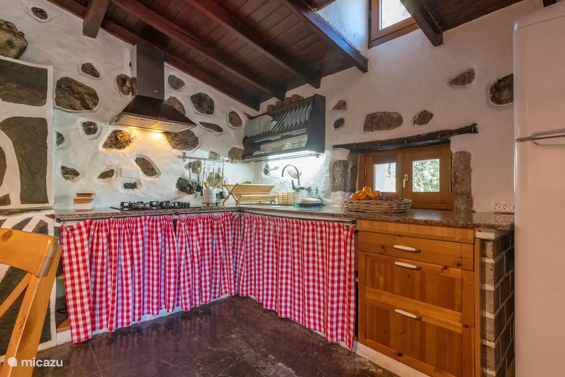 Keuken van een landelijk huis met stenen muren en keramische kookplaat