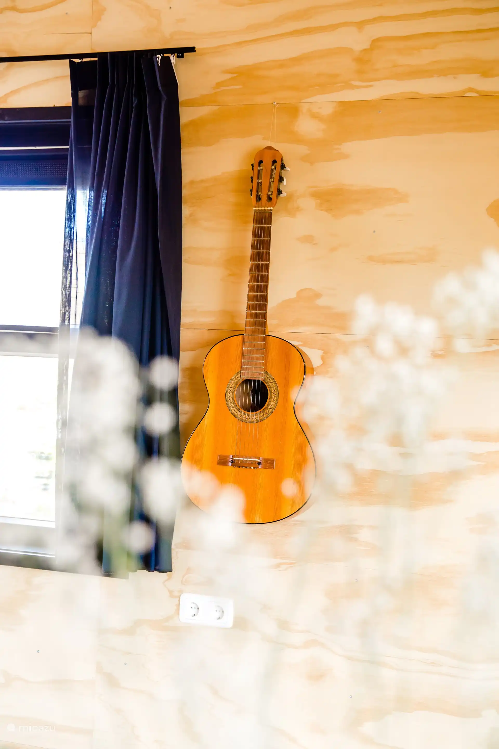 Sfeervol interieurdetail: een gitaar aan de wand.