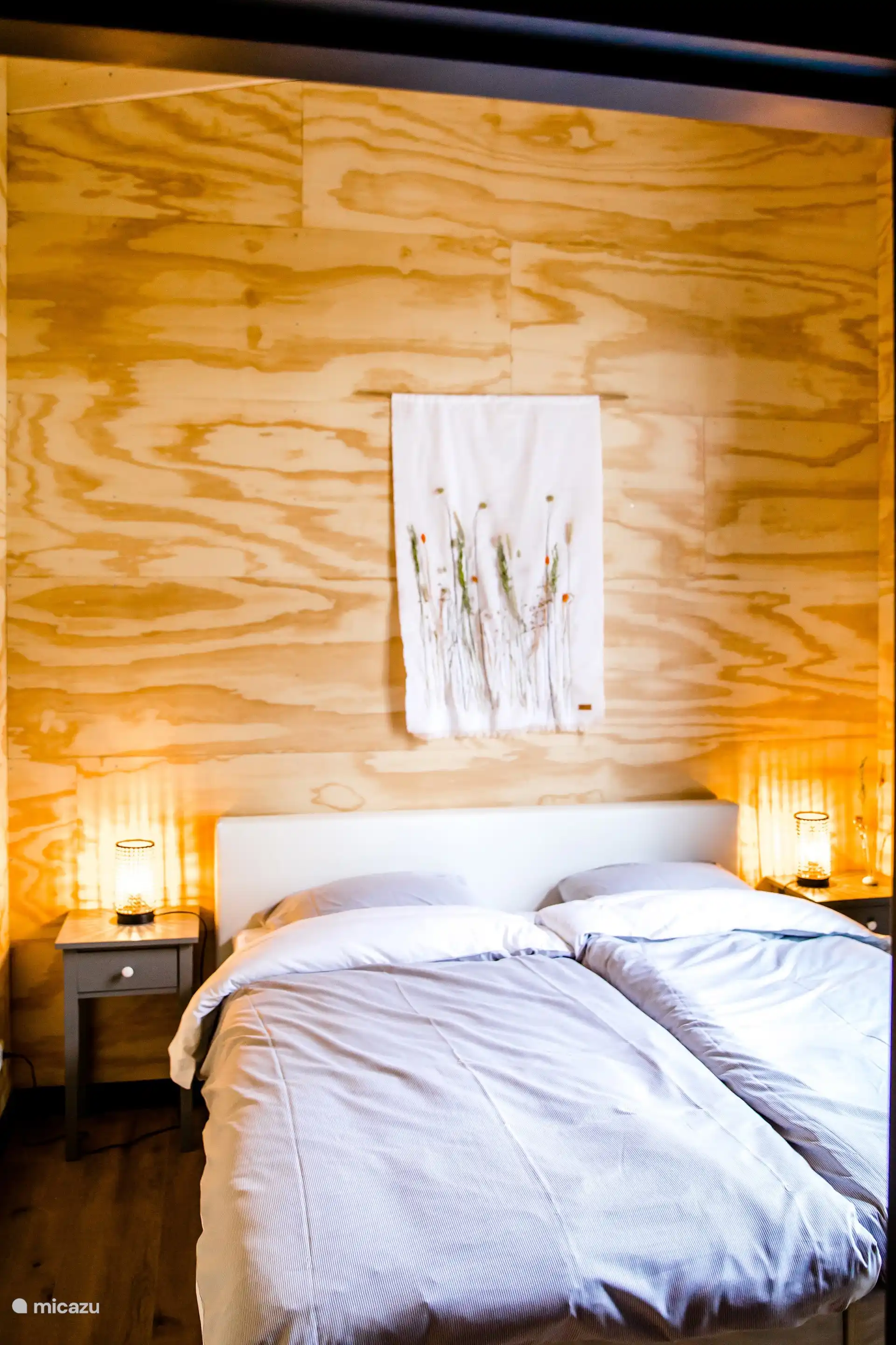 Slaapkamer met een comfortabel tweepersoonsbed en sfeervolle verlichting.
