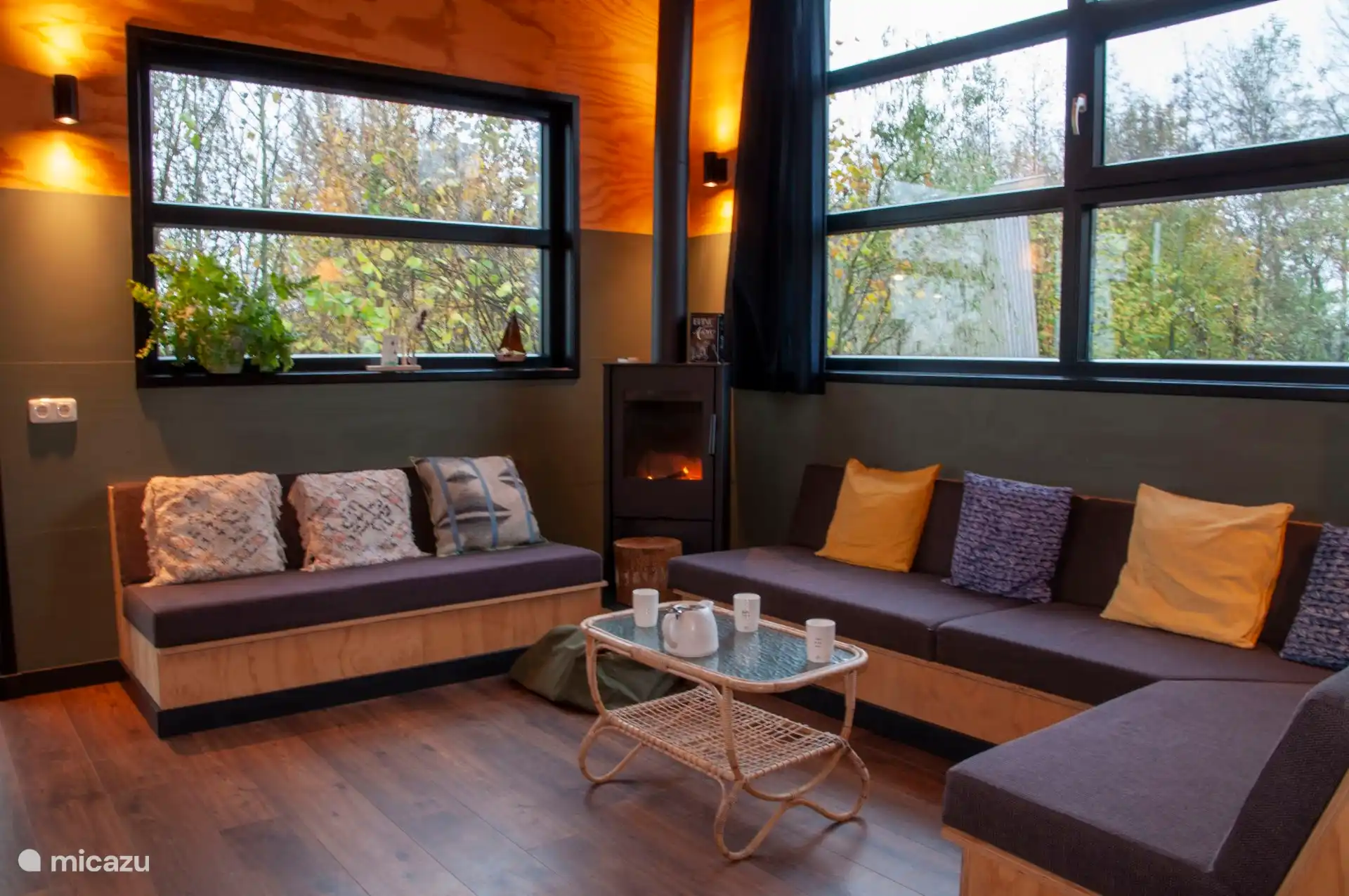 Gezellige zithoek met houtkachel in de woonkamer van de lodge.