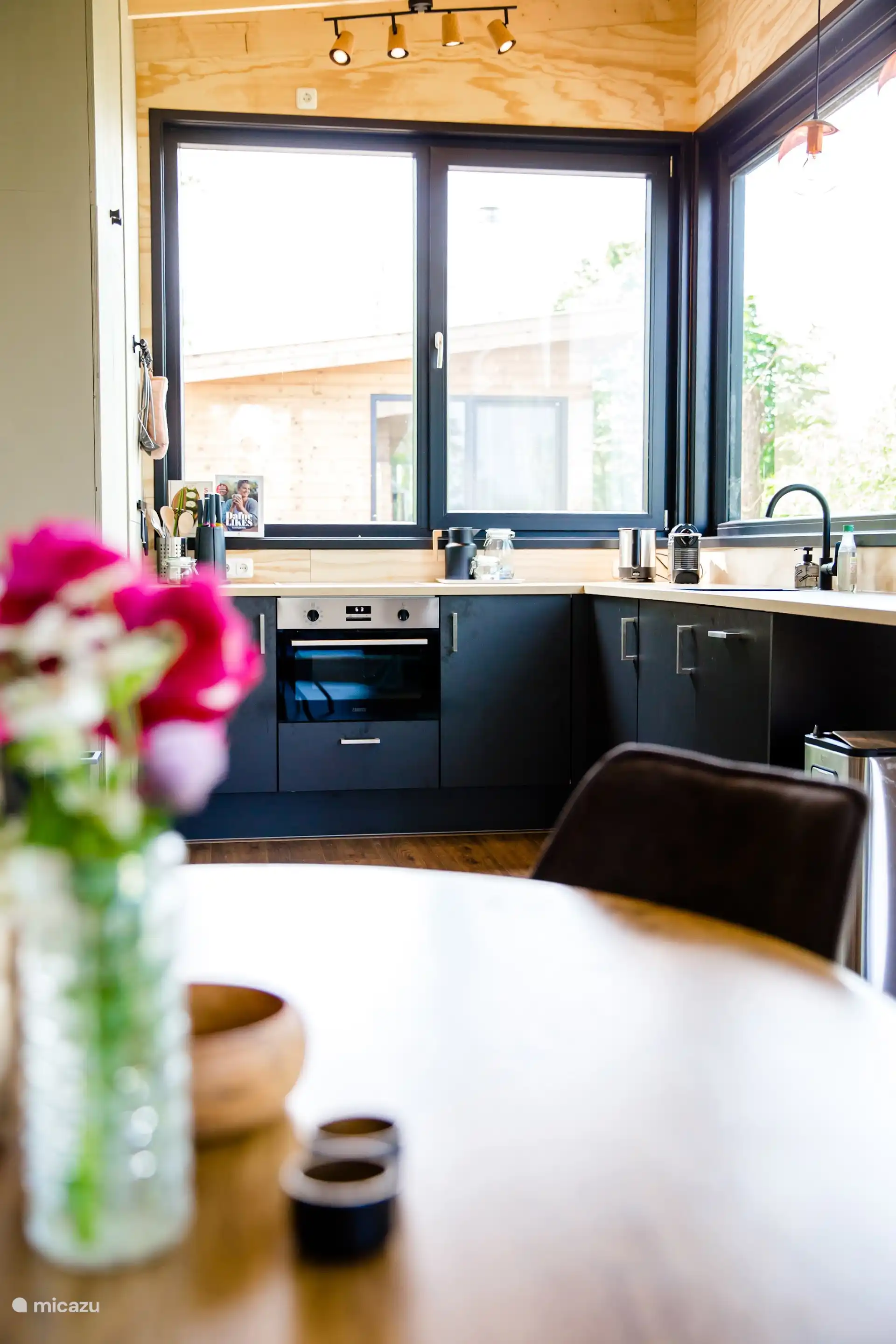 Open keuken met ronde eettafel, een ruime kookplek met alle gemakken en zicht naar buiten.